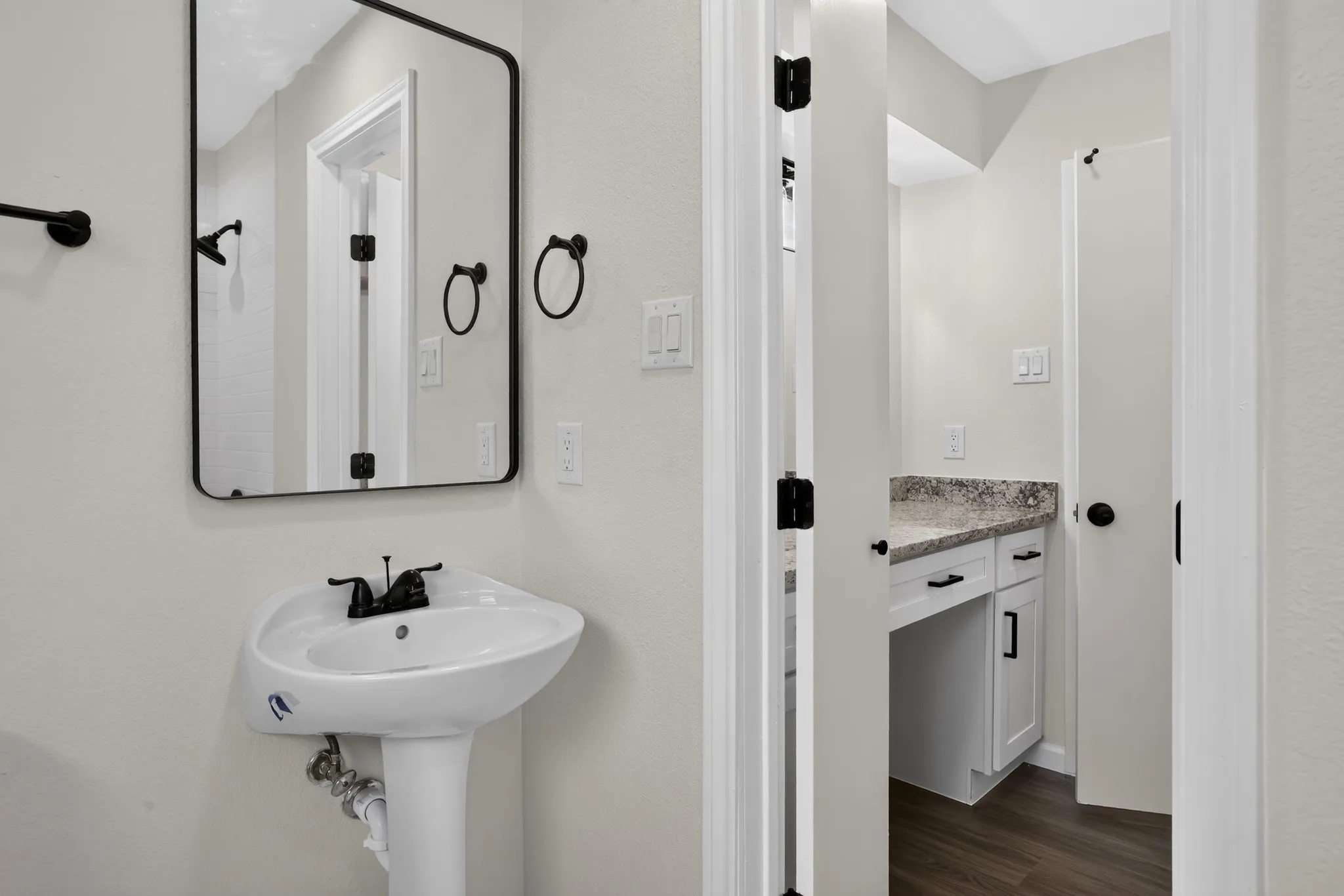 Pedestal sink with matte black faucet and fixtures