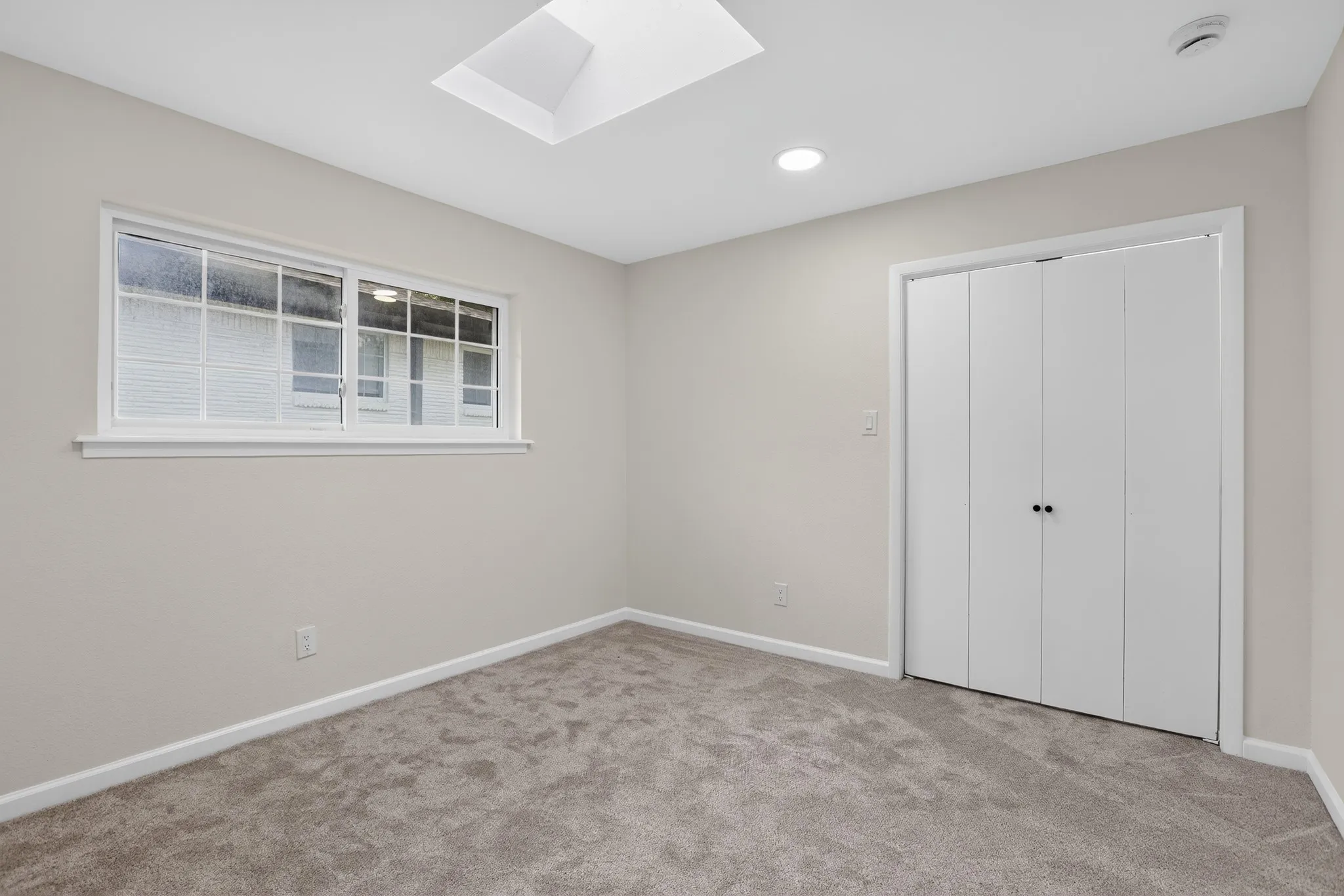 Bedroom featuring a skylight, recessed lighting, and soft gray carpeting