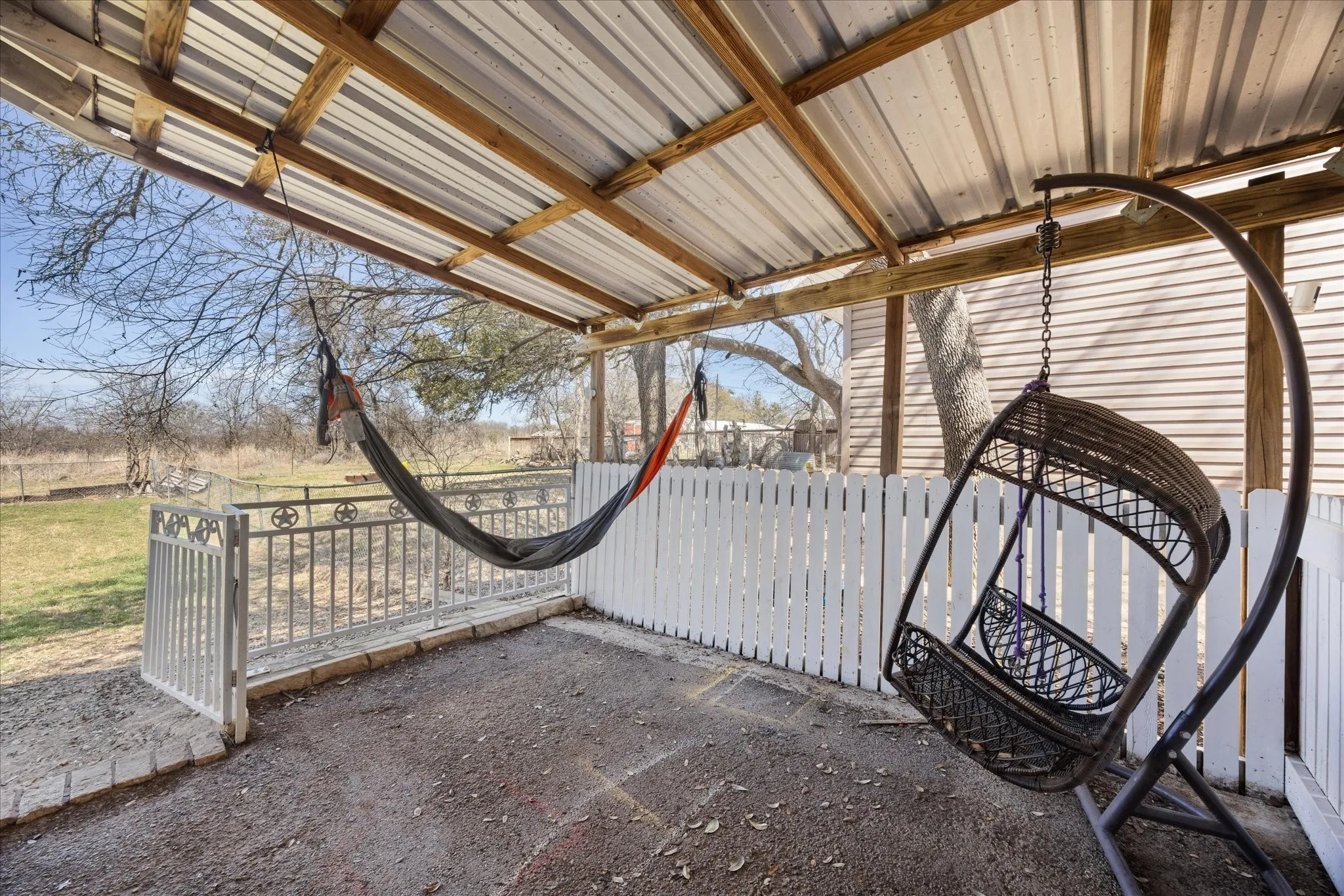 Covered patio featuring a corrugated metal roof supported by exposed timber beams