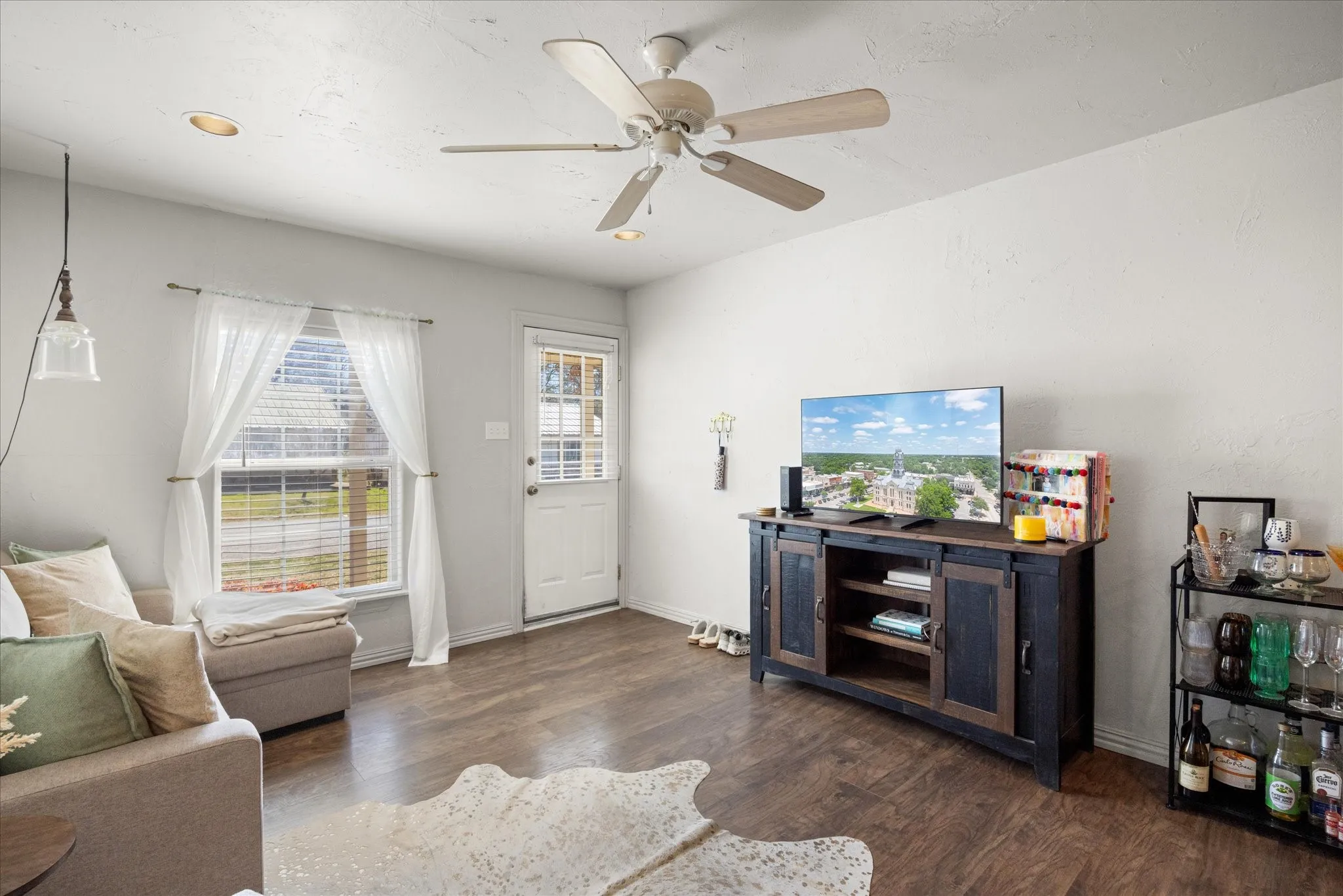 Living area featuring wood-finish flooring, recessed lighting, a ceiling fan with integrated lighting, and a window with blinds