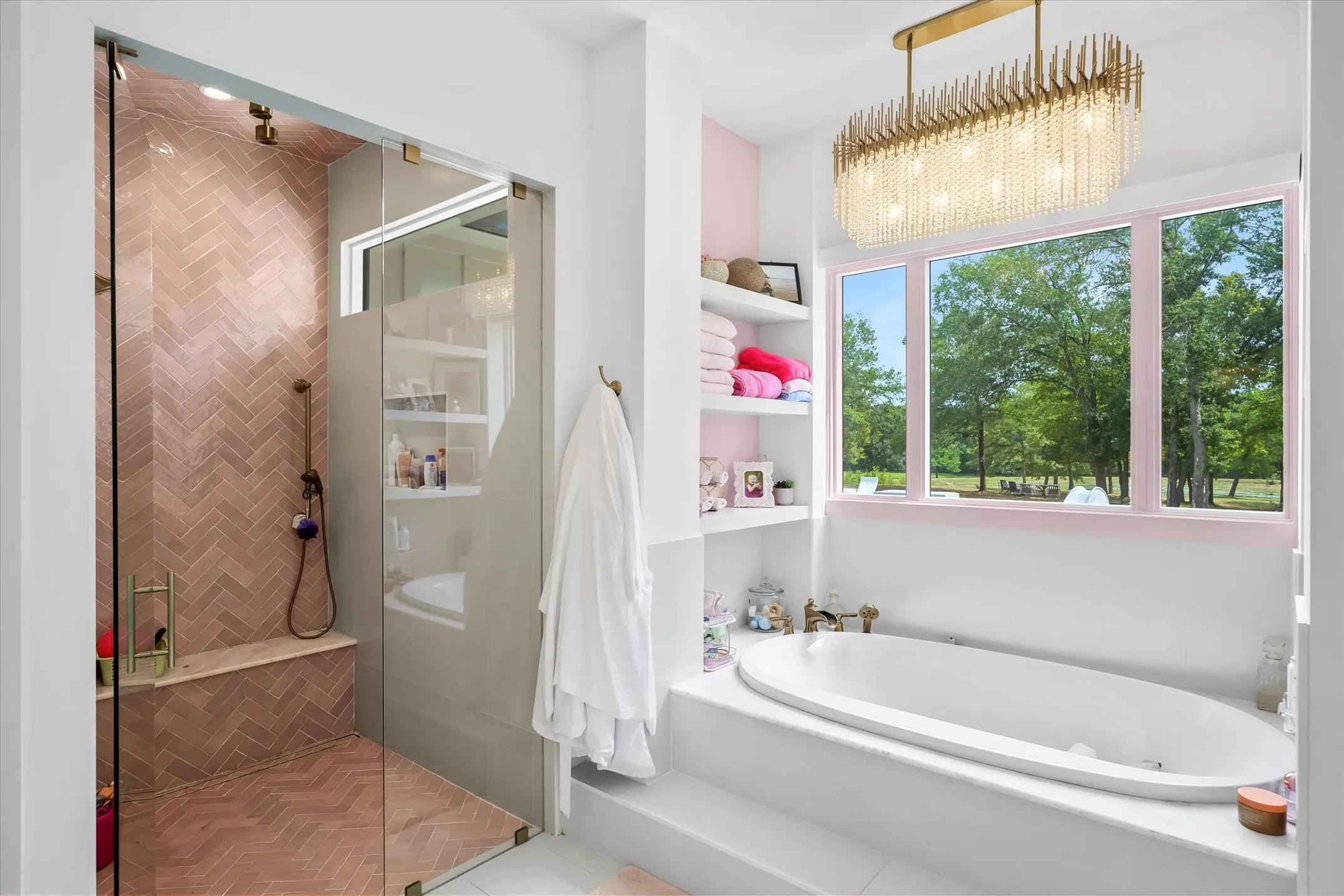 Freestanding soaking tub with a tiled surround, framed by a three-pane window