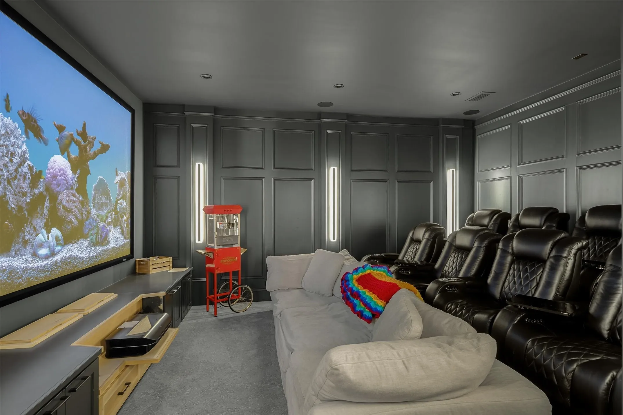 Dedicated media room featuring a large projection screen and built-in media console