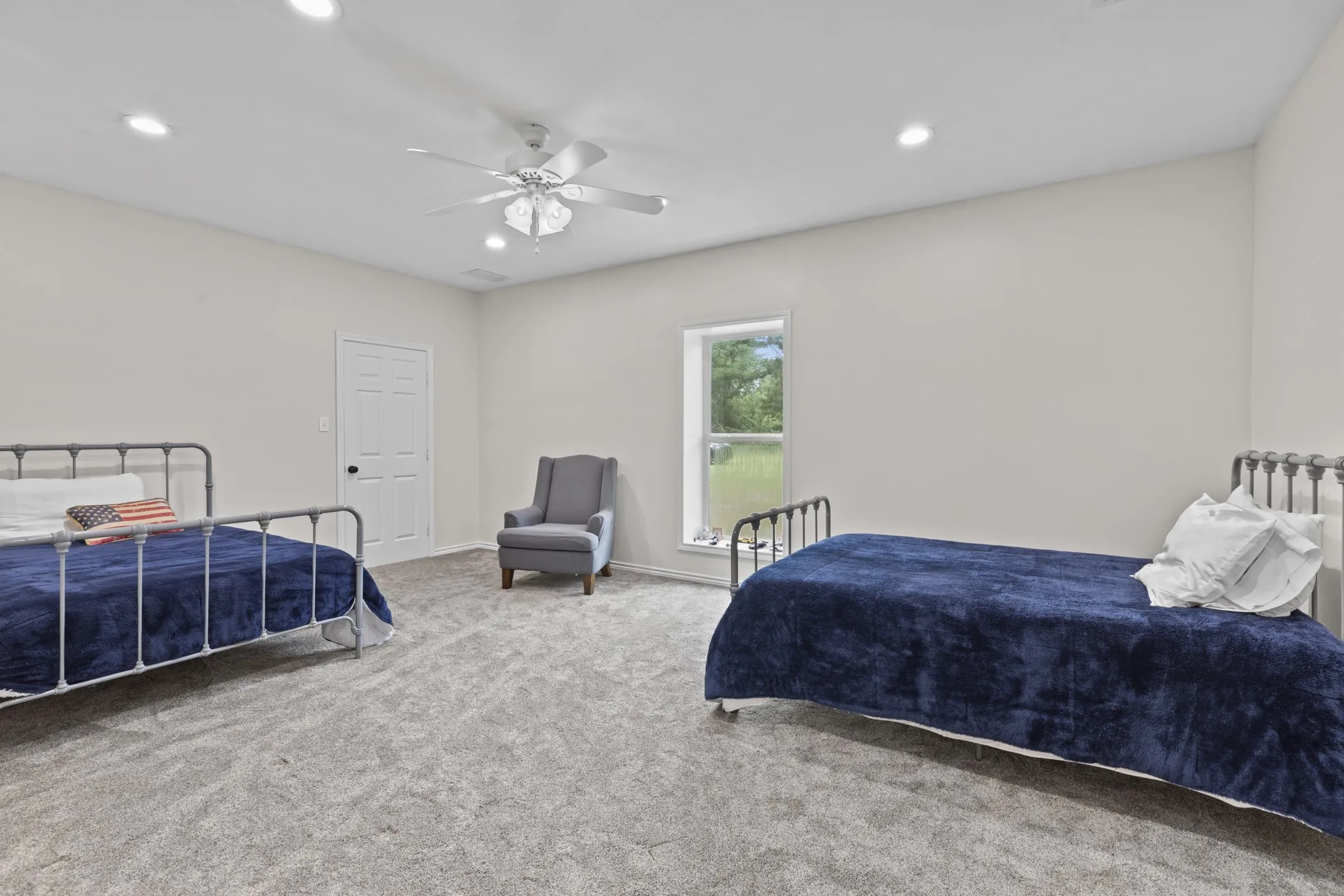 Spacious room featuring neutral carpet flooring, recessed lighting, a ceiling fan, and a window providing natural light