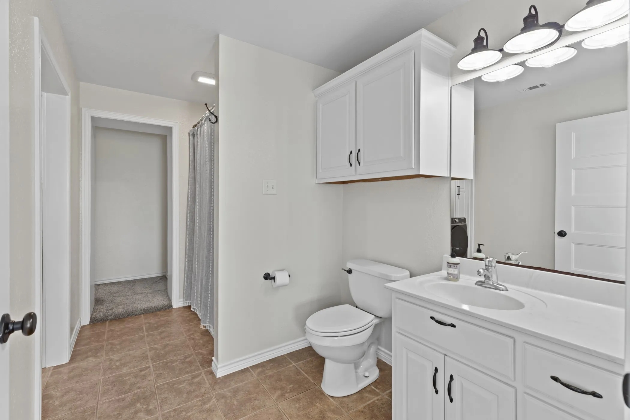 Bathroom featuring a single vanity with white cabinetry and a white countertop