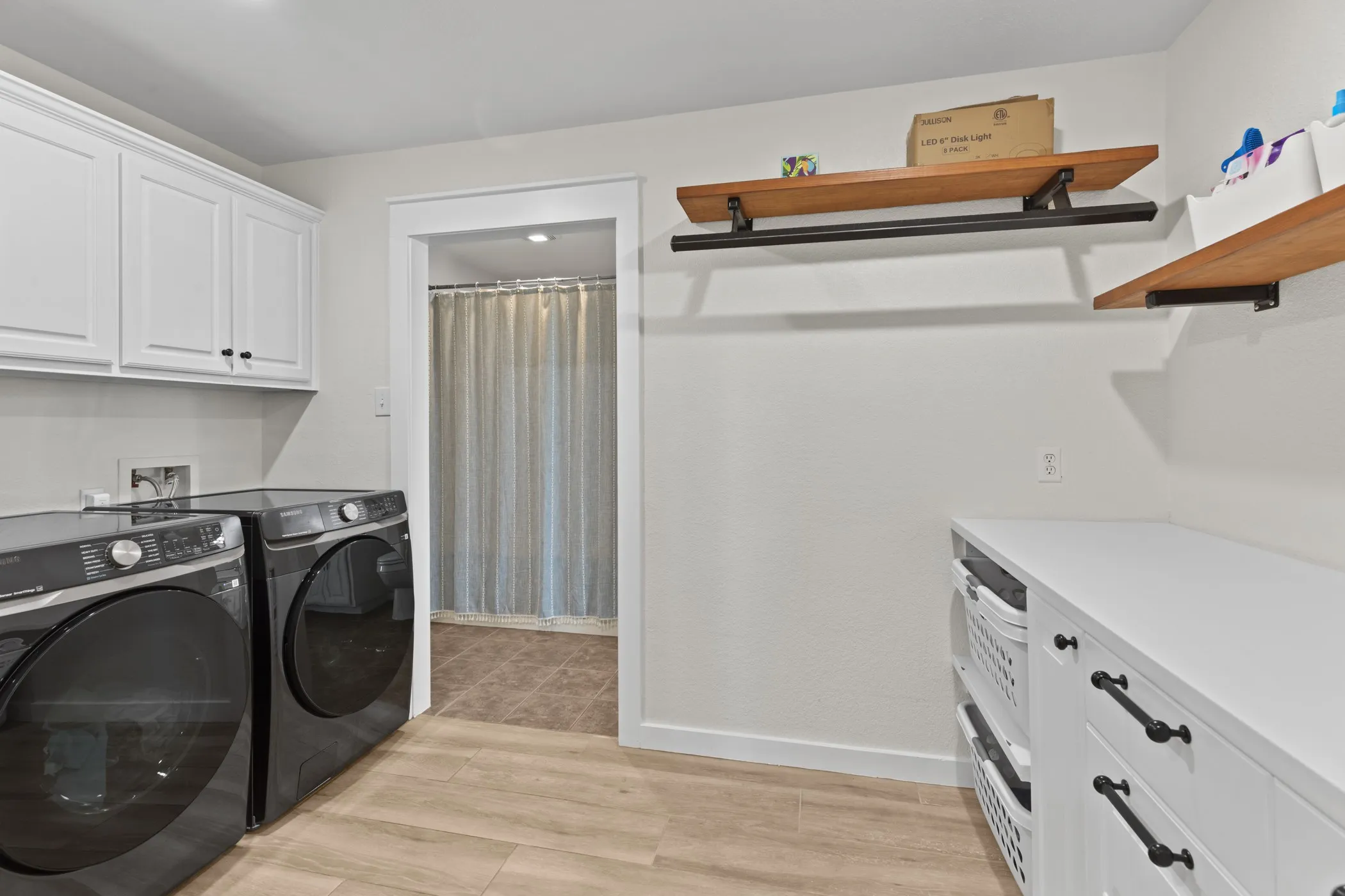 Dedicated utility space featuring light wood-finish flooring