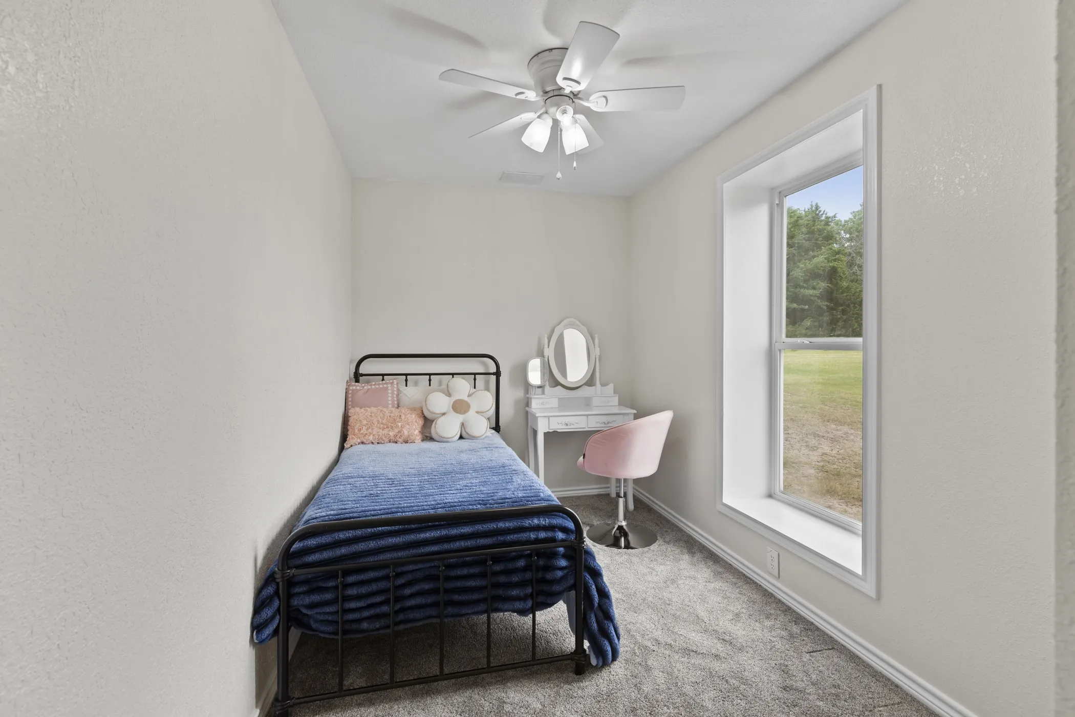 Bright room with a large window, neutral wall paint, and gray carpet flooring