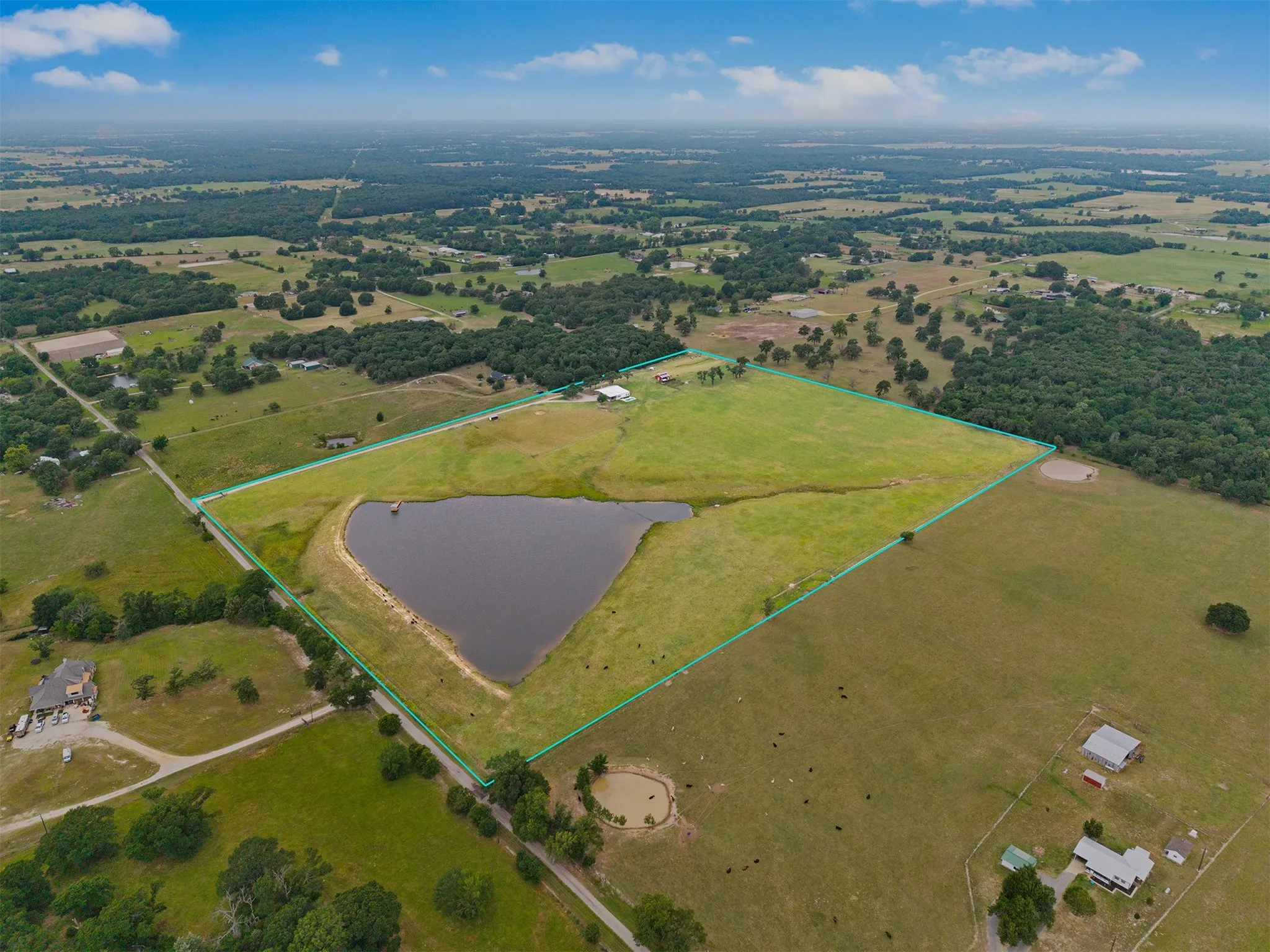 Expansive rural property featuring open fields and wooded areas