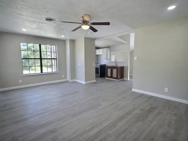 Open concept living area with wood-finish flooring, recessed lighting, and a ceiling fan