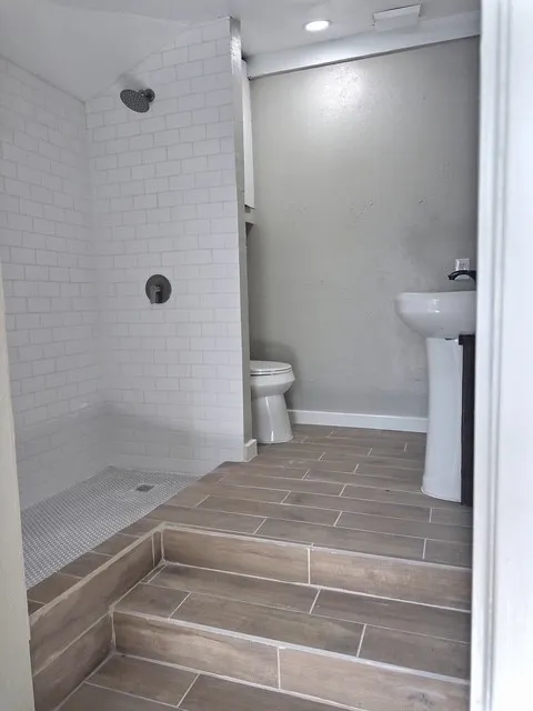 Shower with subway tile surround and a tiled shower floor