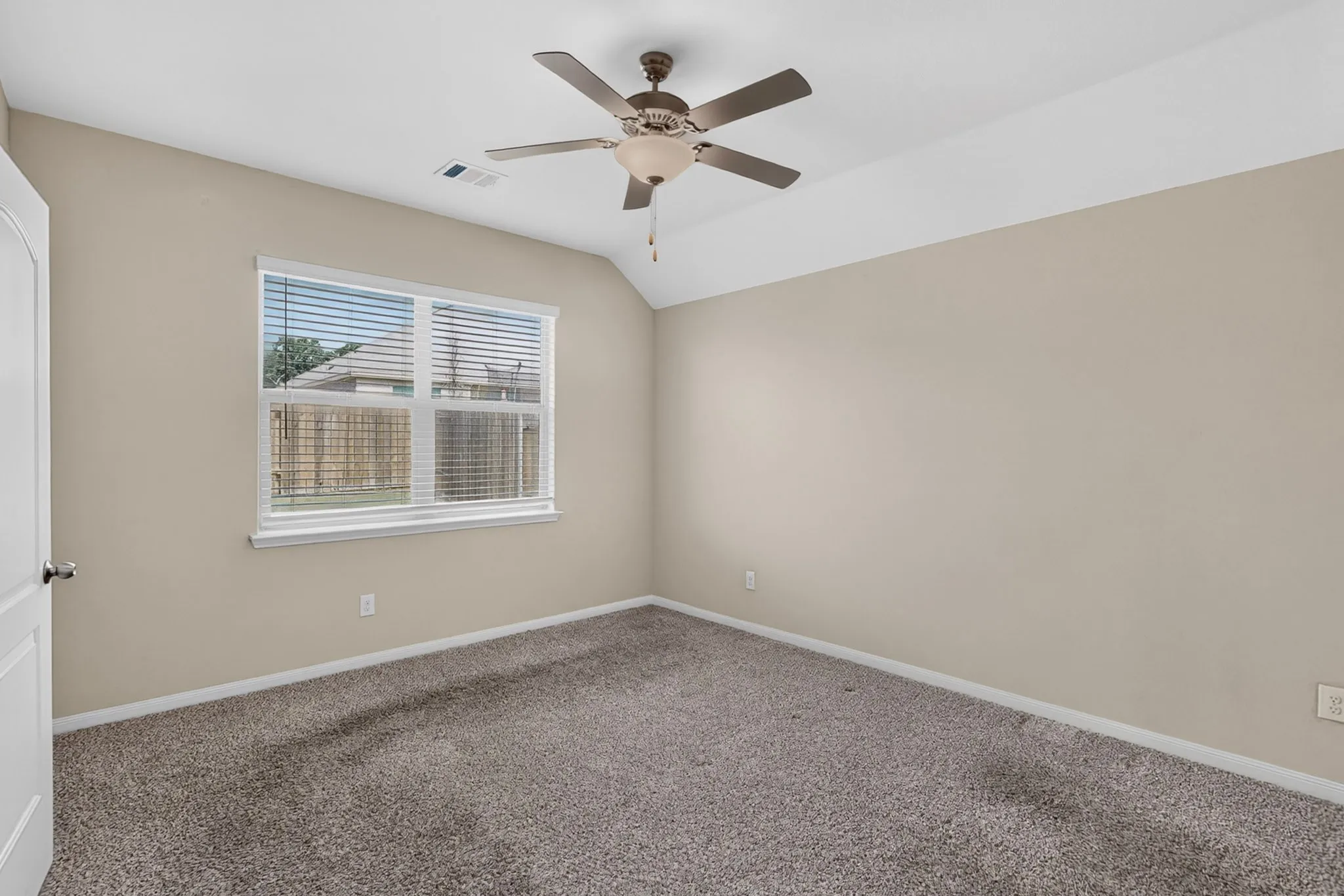 Carpeted room featuring a ceiling fan with integrated lighting, a window with horizontal blinds, and neutral wall tones