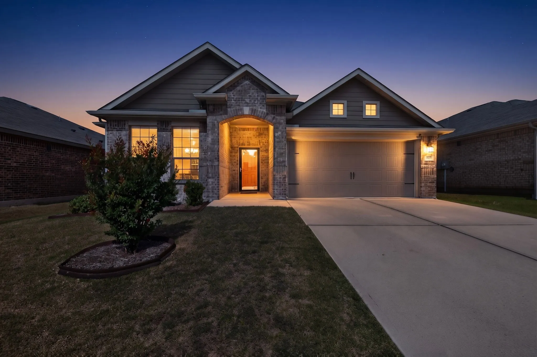 Brick and siding exterior featuring an arched entryway