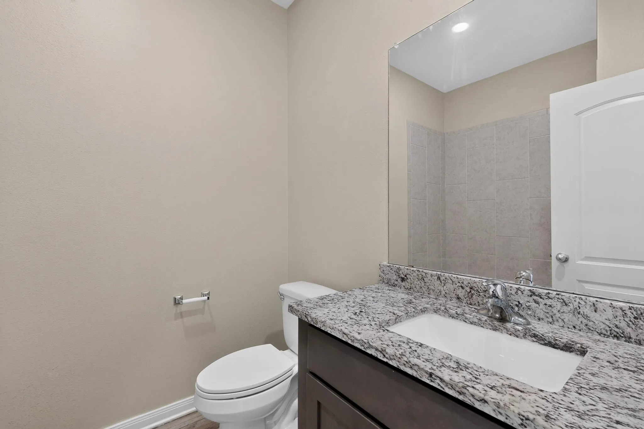 Vanity featuring a stone countertop, an undermount sink, and chrome fixtures