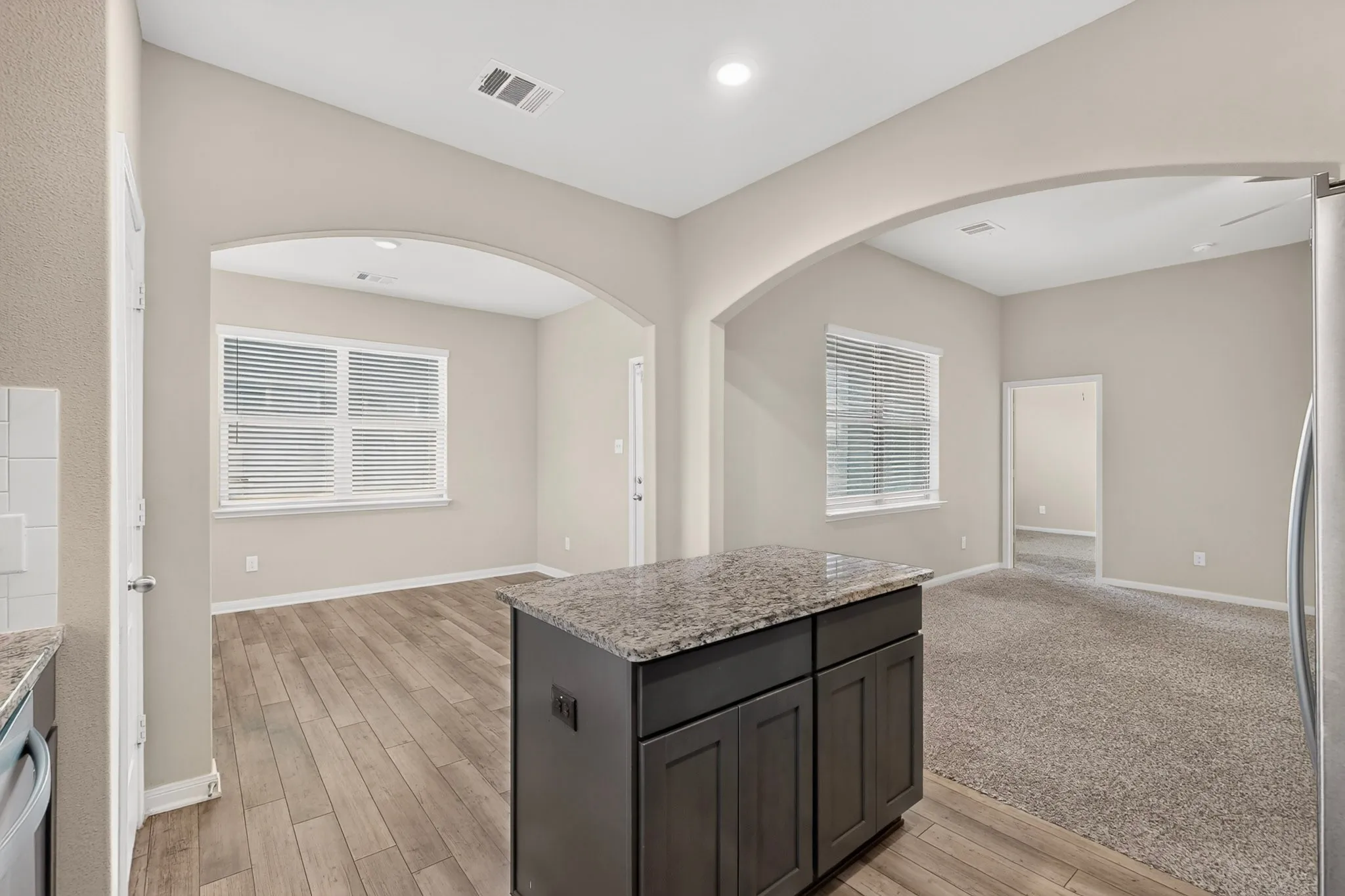 Kitchen island with a granite-style countertop and dark wood-finish cabinetry