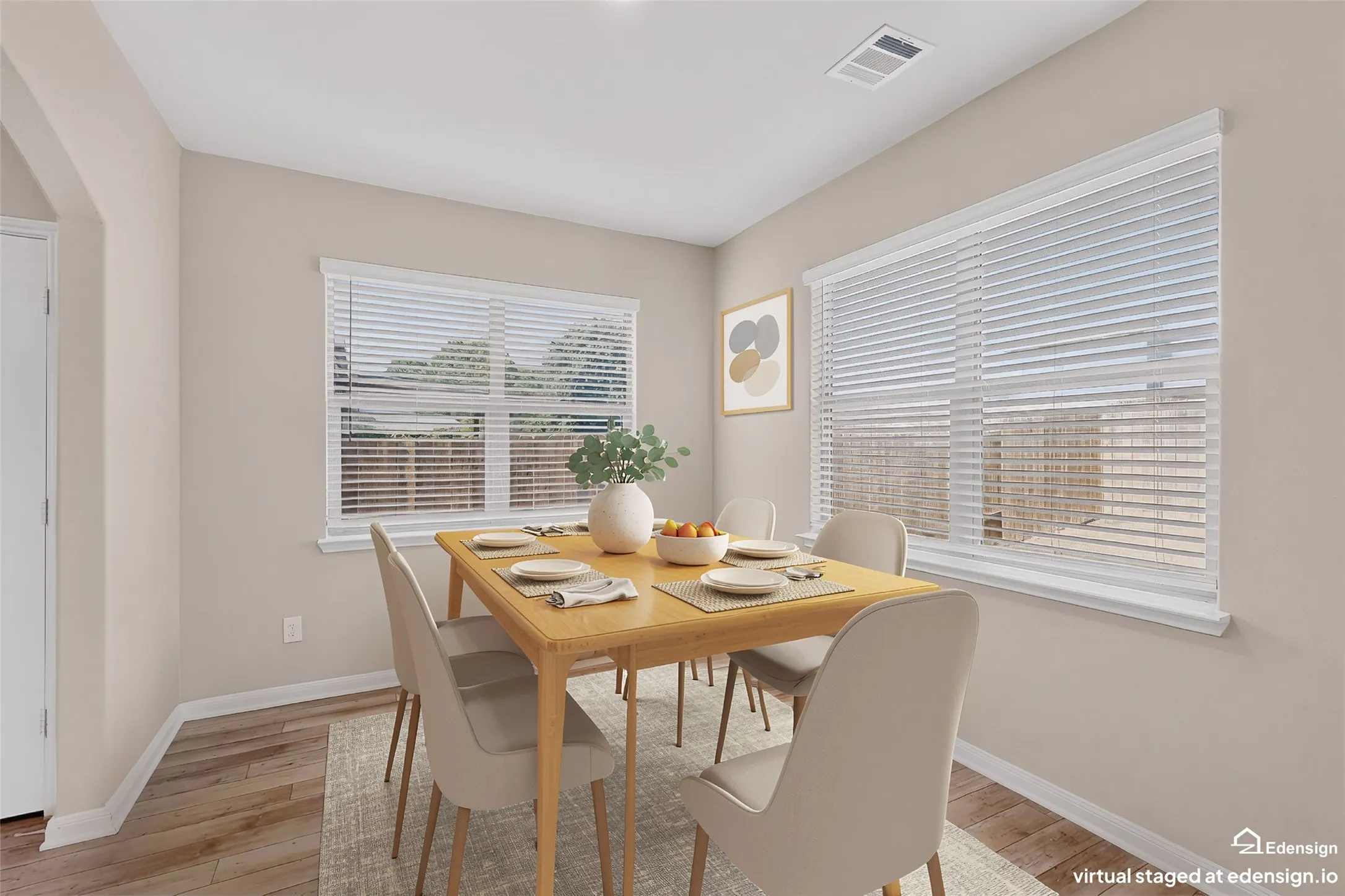 Dining area featuring wood-finish flooring, light neutral walls, and white baseboards
