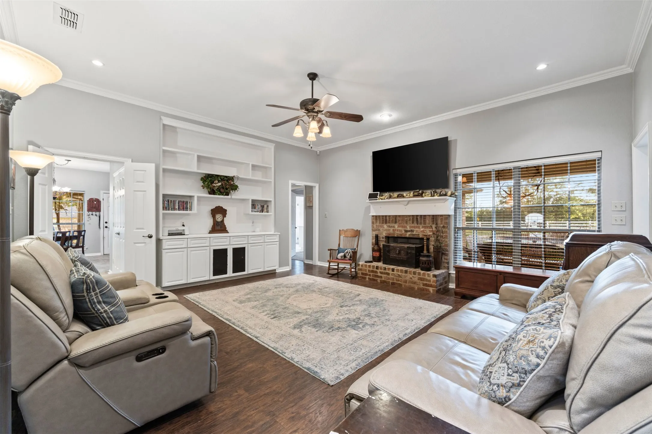 Living room with wood burning fireplace and built-in shelving.