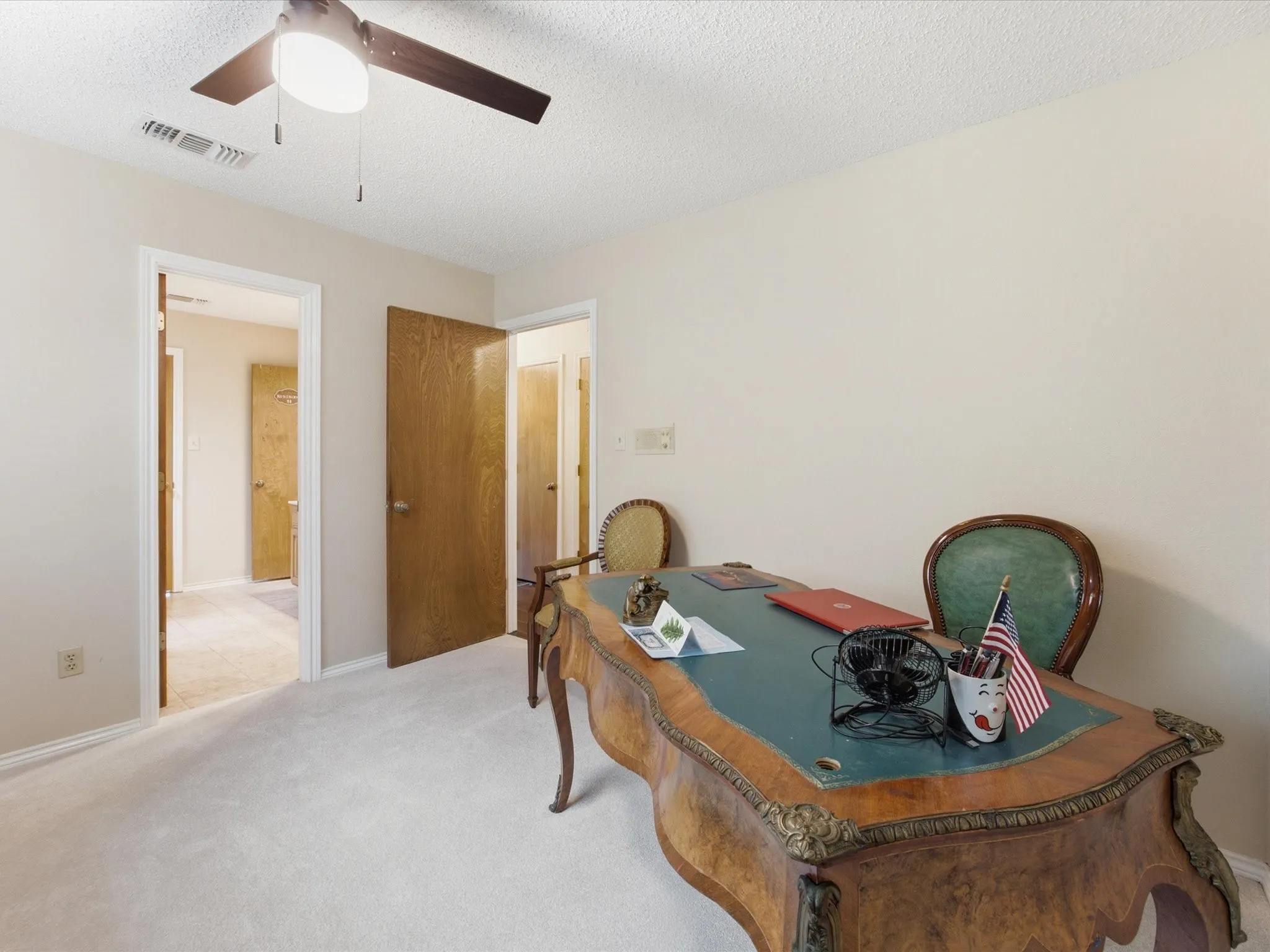 Bedroom featuring neutral wall paint, light-colored carpet flooring, a ceiling fan with integrated lighting, and multiple doorways