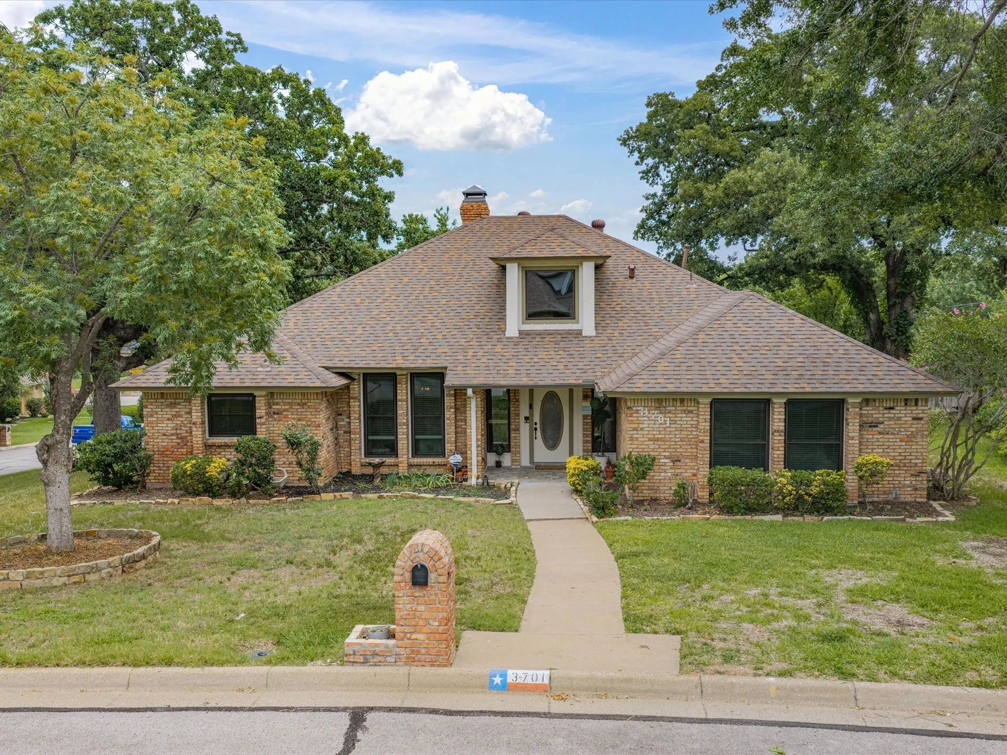 Brick exterior residence featuring a gabled roofline and an upper-level dormer