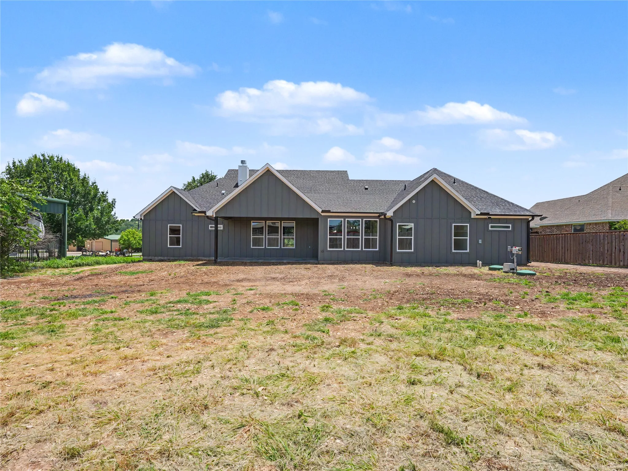 Contemporary ranch-style home featuring gray vertical siding and white trim accents