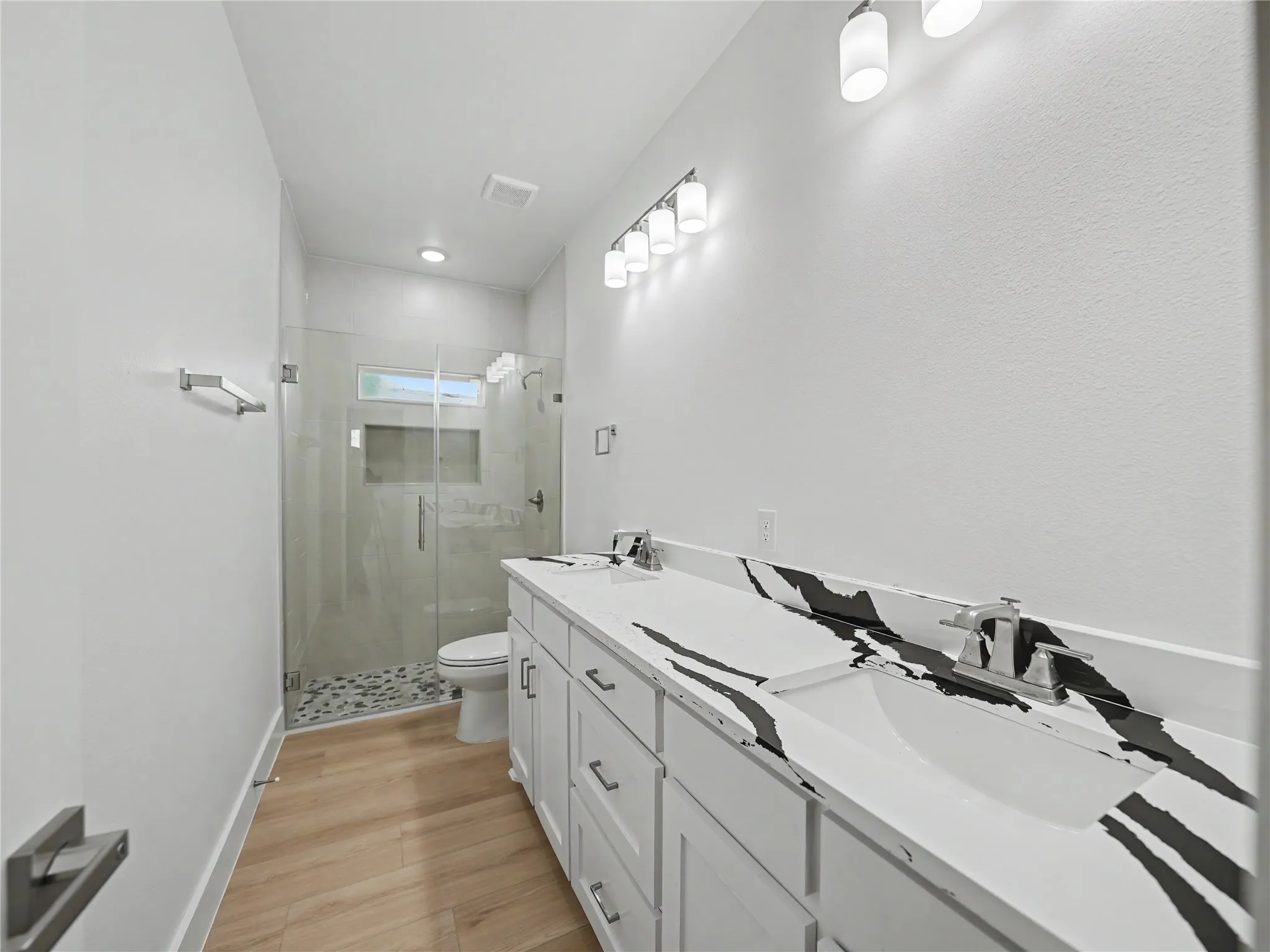 Dual vanity with white cabinetry and striking black and white patterned countertops