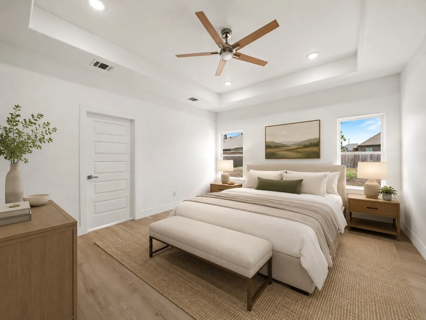 Spacious room featuring a tray ceiling with recessed lighting and a contemporary ceiling fan