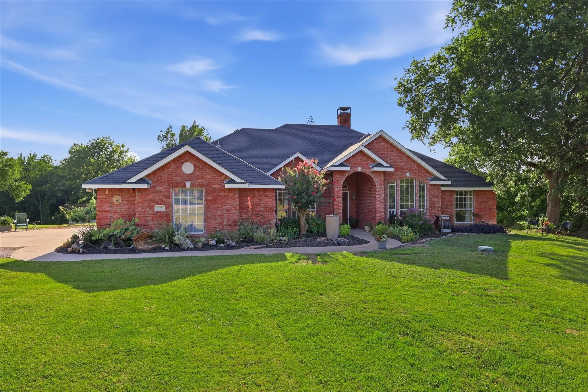 Brick exterior with dark shingle roofing and white trim accents