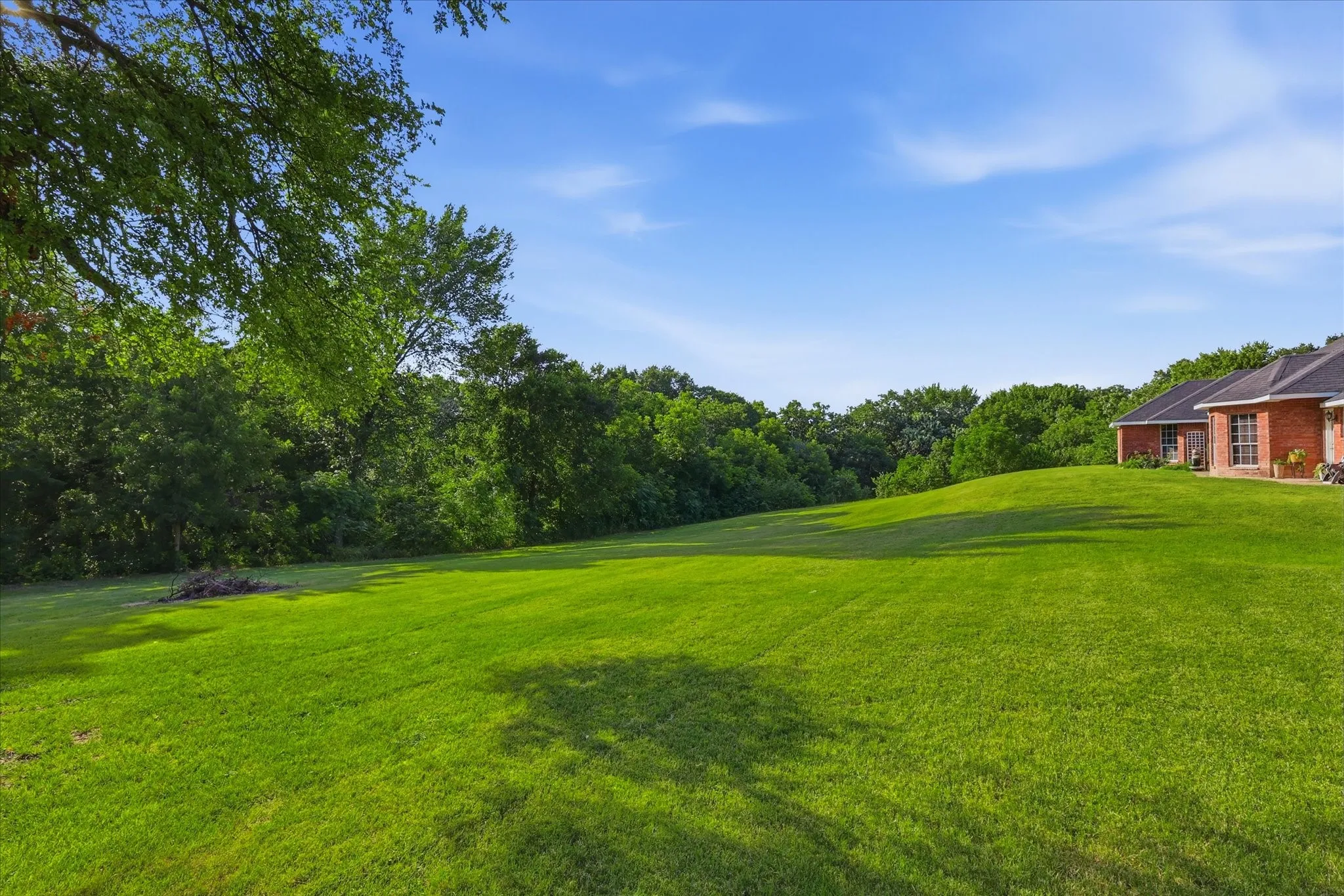 Expansive grassy lawn with a gentle slope