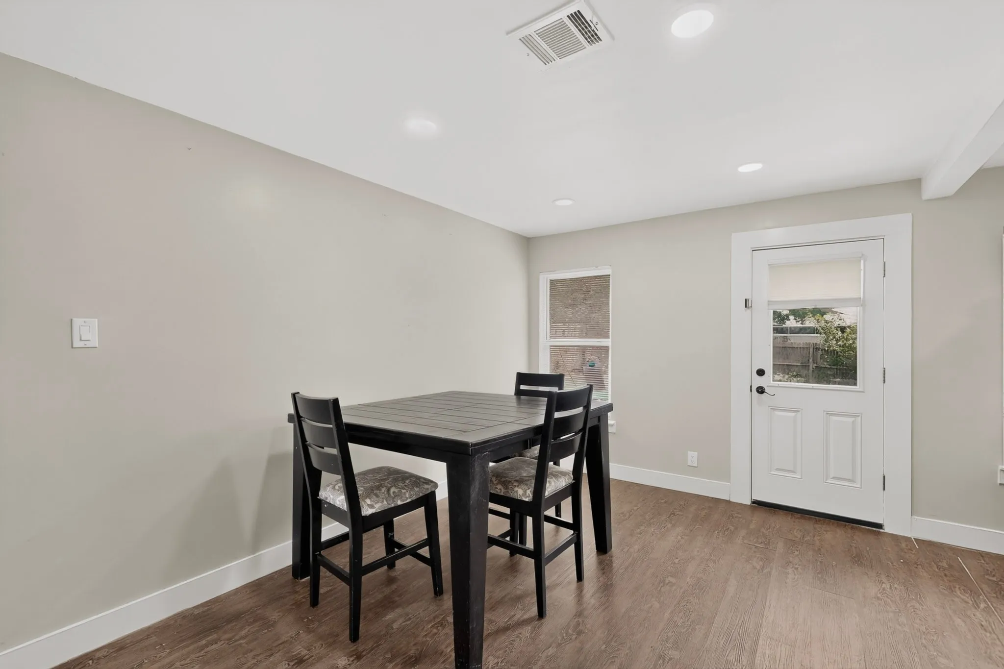Neutral tone walls complement the wood-finish flooring