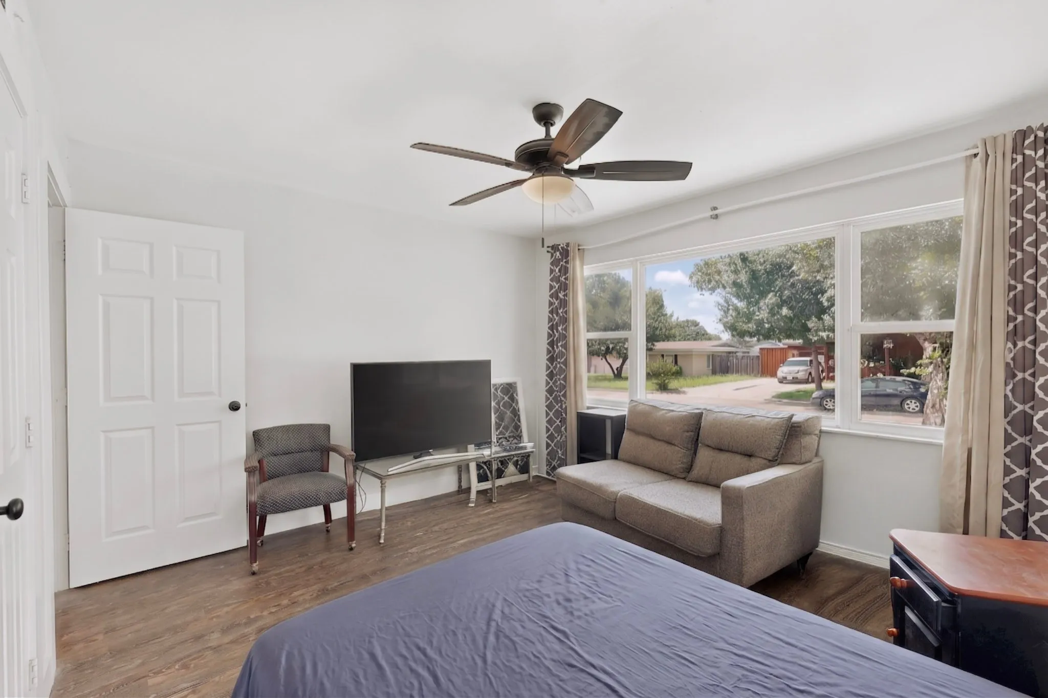Interior room featuring wood-finish flooring, white walls, and a multi-pane window