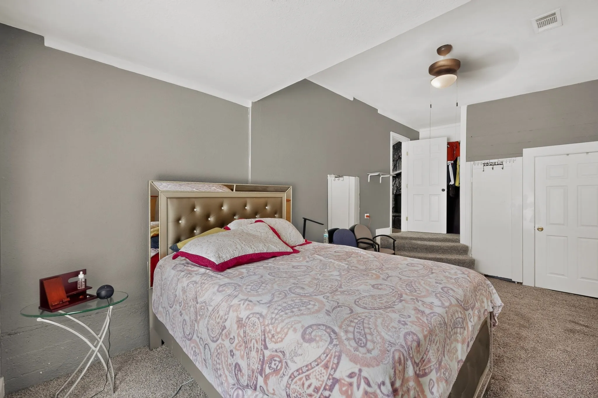 Carpeted room with a ceiling fan light fixture, light gray walls, and white trim