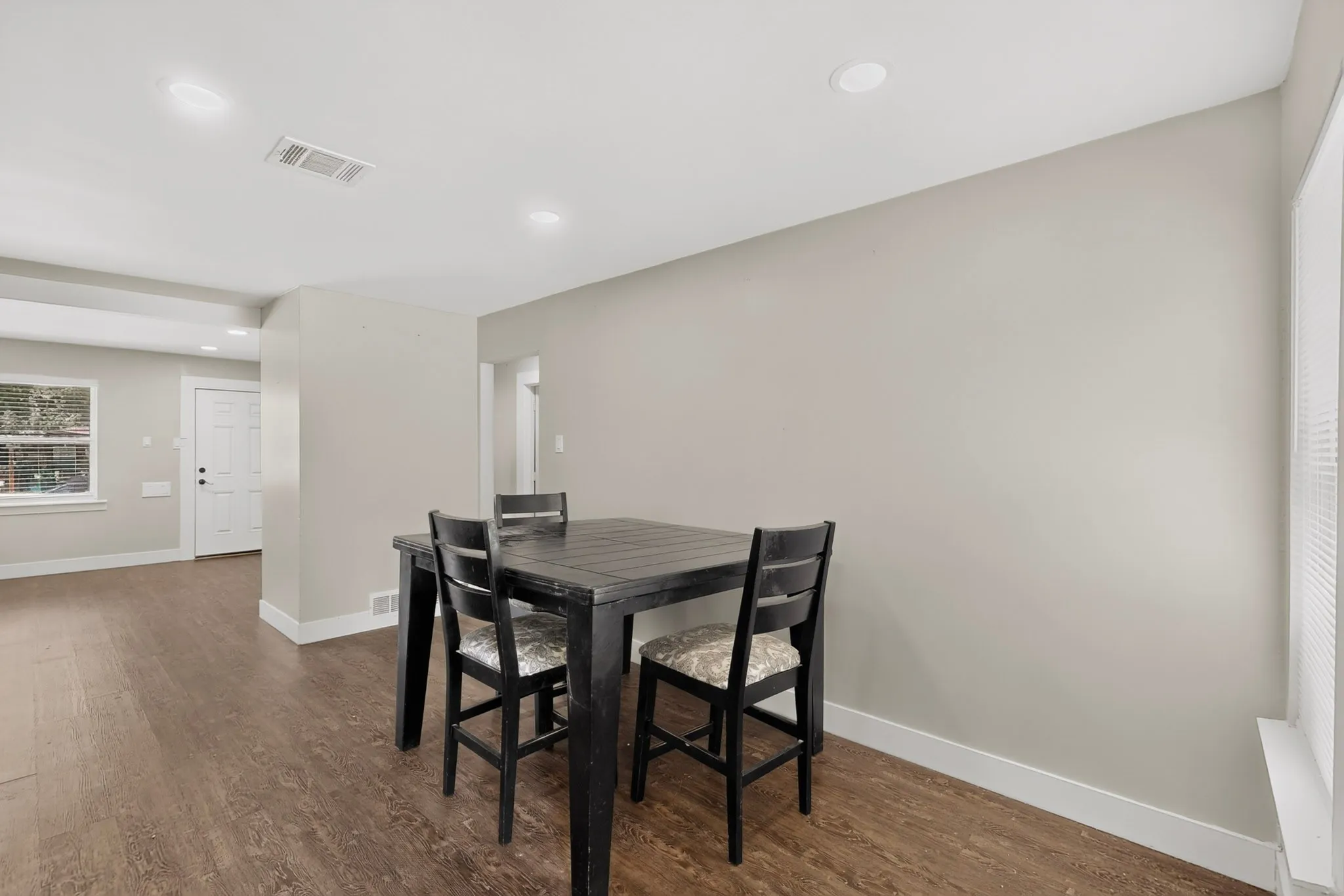 Open concept living area featuring wood-finish flooring, recessed lighting, and light neutral wall paint