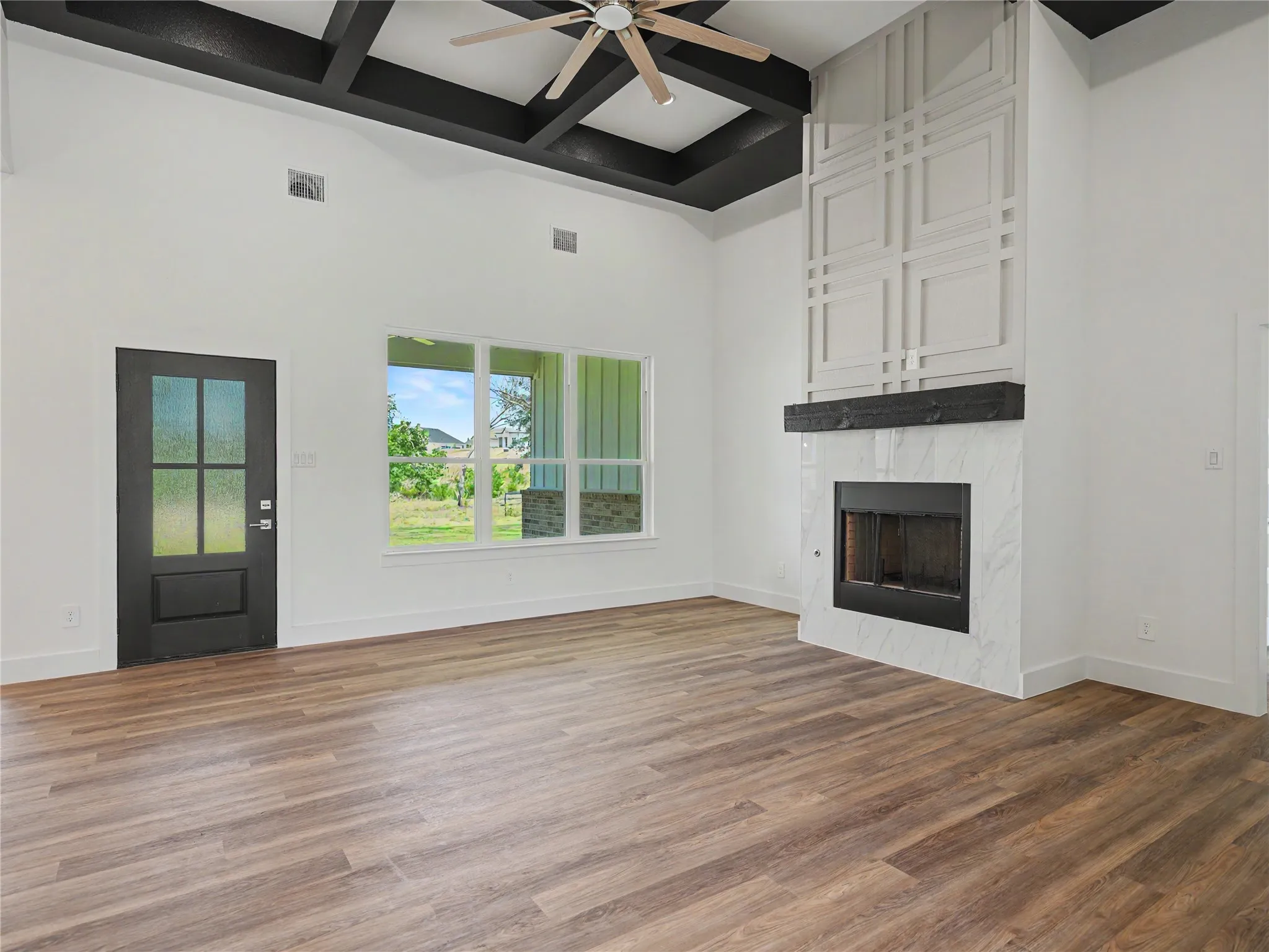 Vaulted ceiling with dark-stained exposed beams and a ceiling fan
