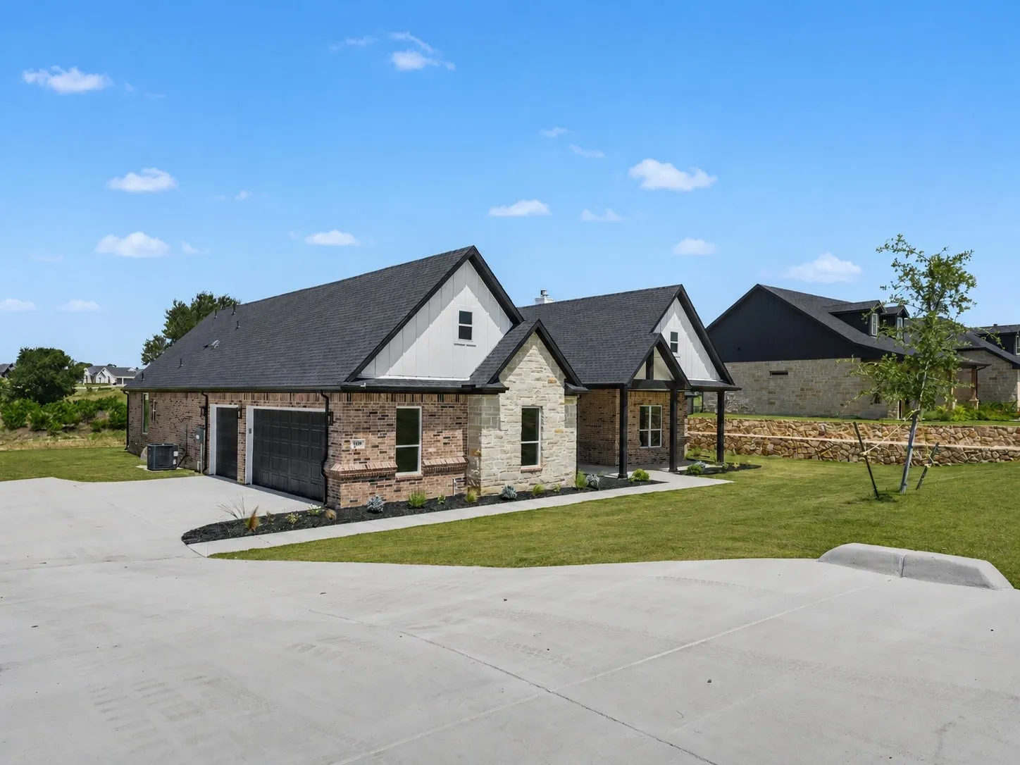 Contemporary single-story residence featuring a combination brick and stone facade