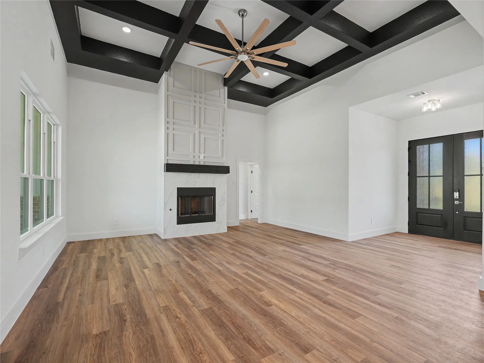 Expansive living area with a coffered ceiling and a large ceiling fan