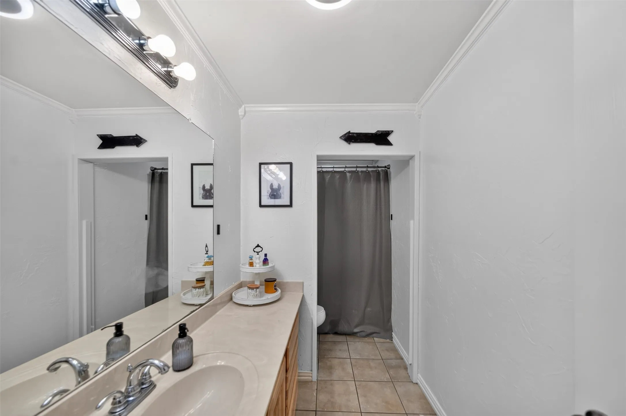 Bathroom featuring a single vanity with an integrated sink, chrome faucet, and a light-toned countertop