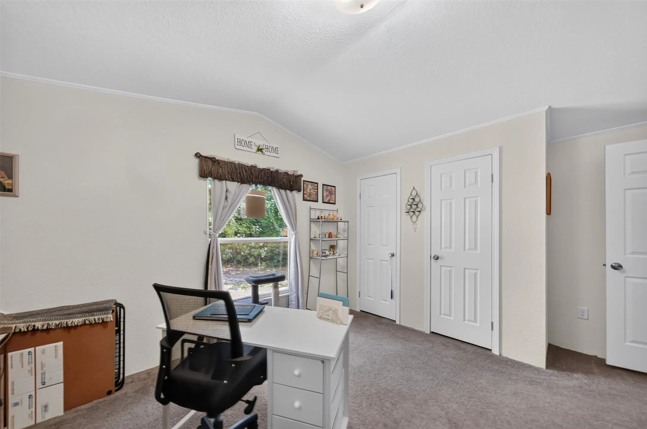 Room featuring vaulted ceilings and neutral wall tones
