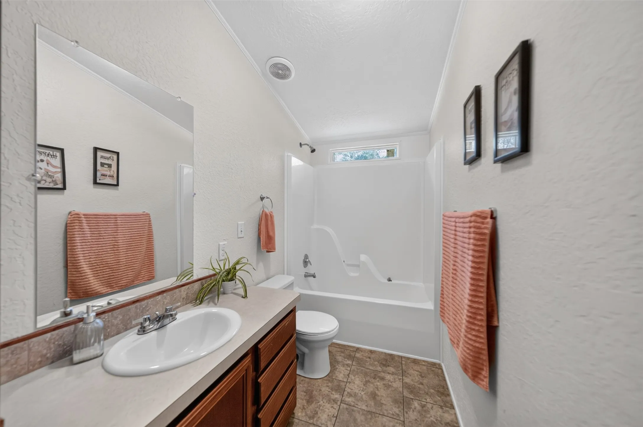 Full bathroom featuring a single vanity with wood cabinetry, a large wall mirror, and a tub-shower combination