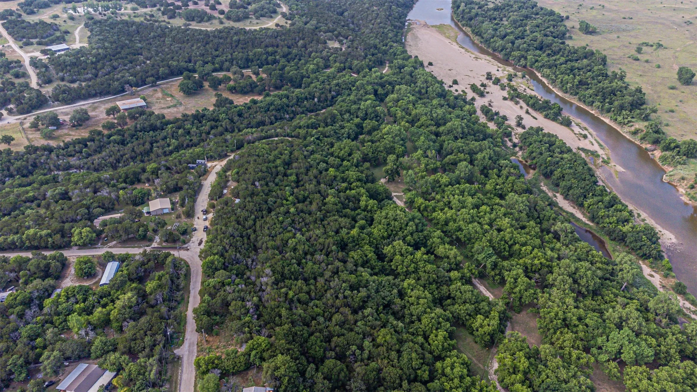 Aerial perspective showcasing a verdant landscape with extensive tree coverage and a meandering river