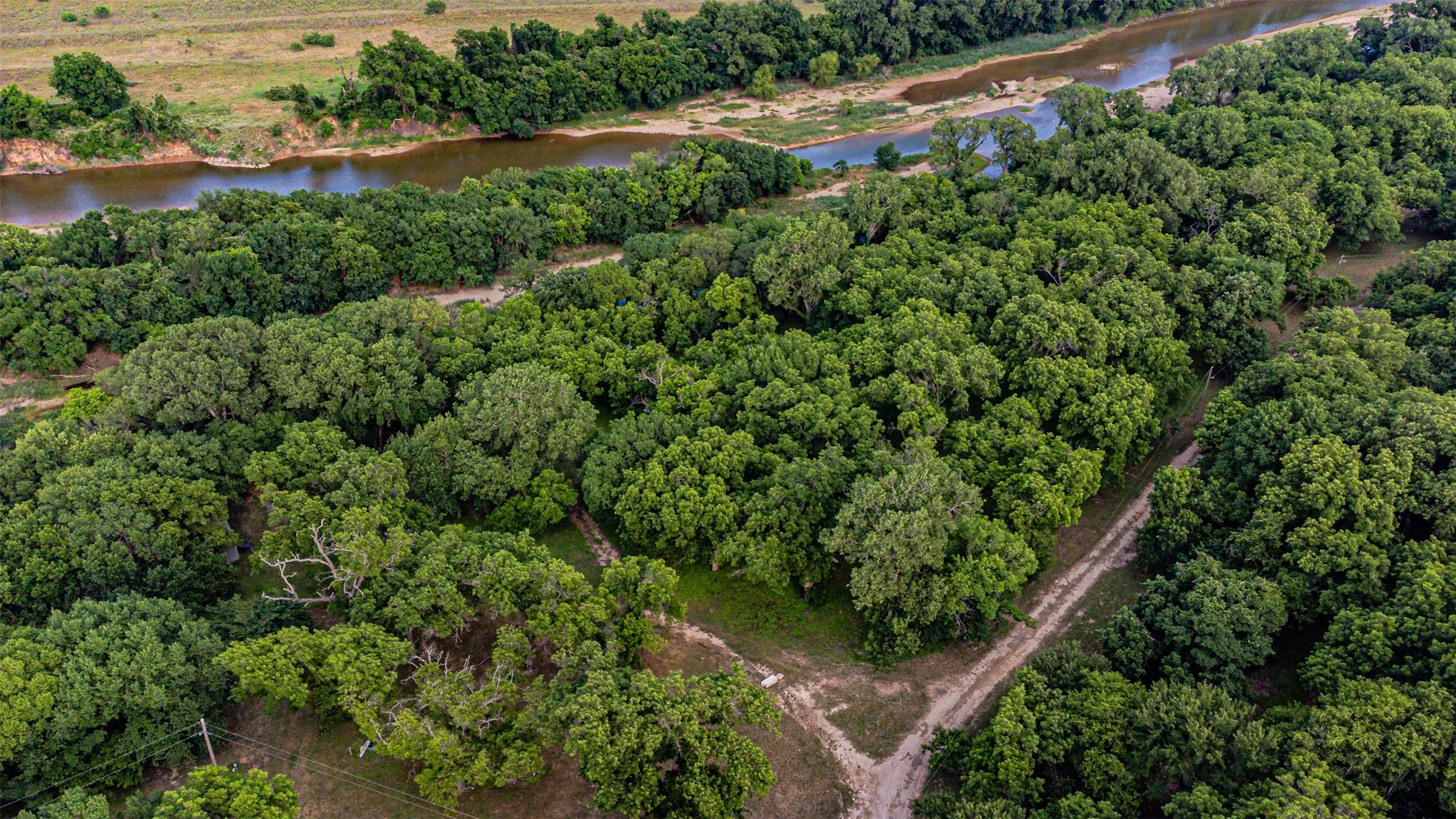 Expansive acreage featuring dense tree coverage and direct river frontage