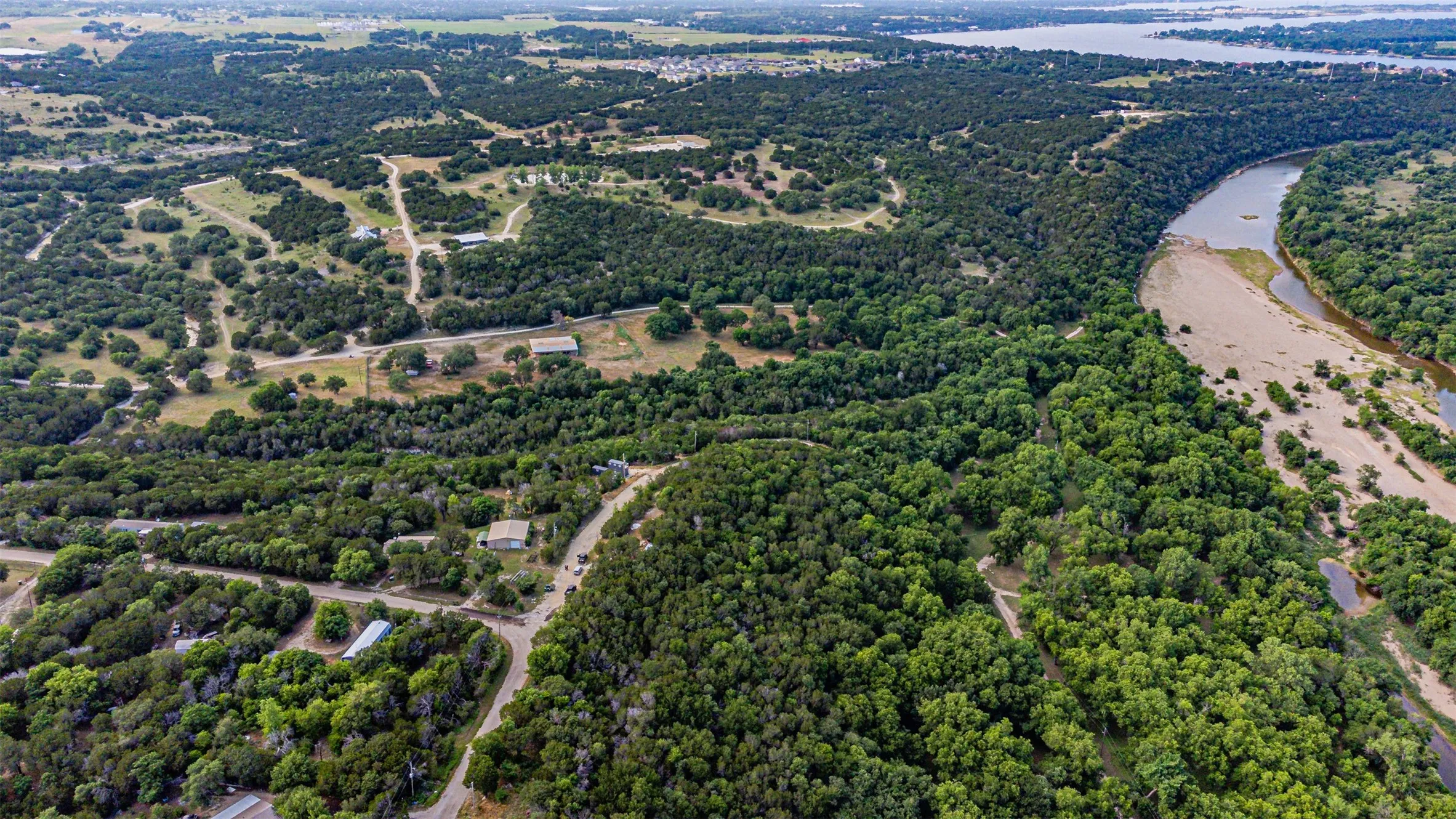 Expansive aerial view showcasing a river with sandy banks and significant tree coverage