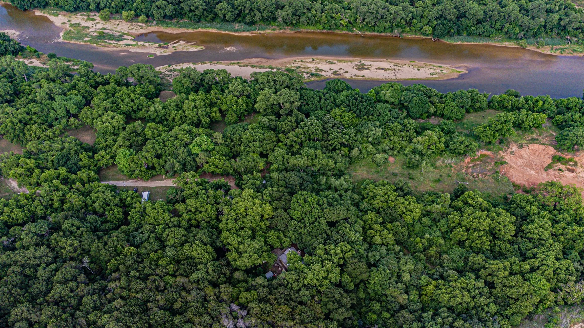 Expansive treed acreage with direct river frontage