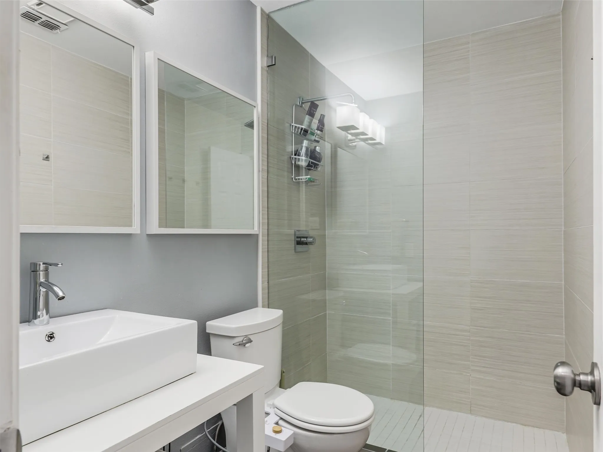 Bathroom two featuring a rectangular vessel sink, chrome faucet, and dual mirrors.