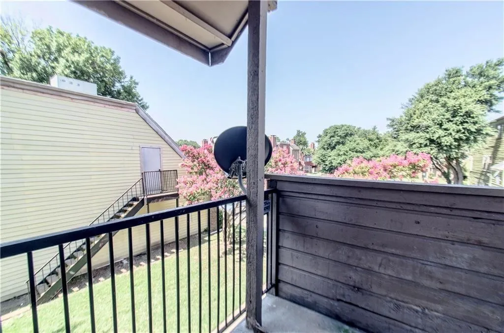 Private balcony featuring a wood-panel railing and concrete flooring