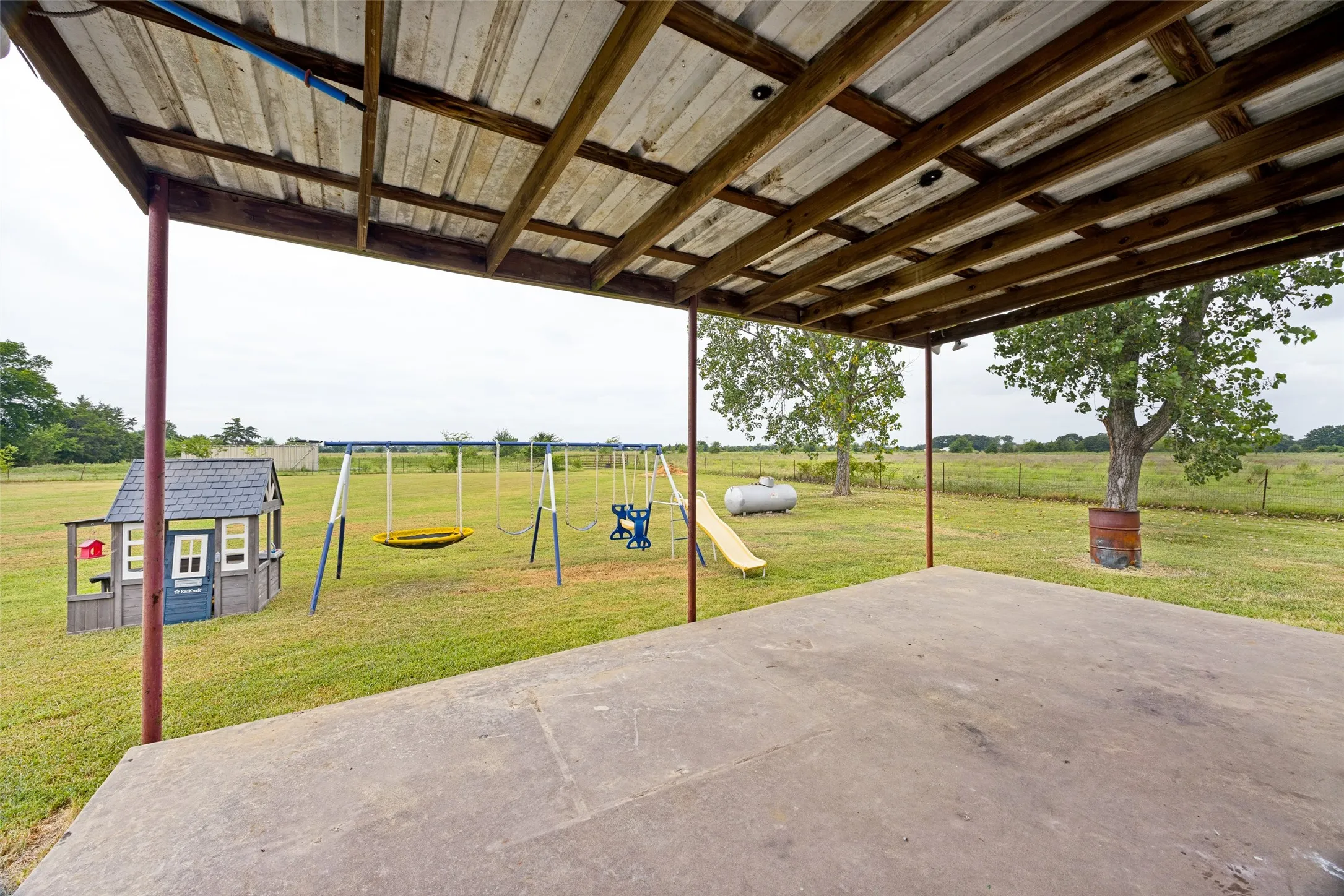 Expansive concrete patio beneath a wood-framed, corrugated metal roof