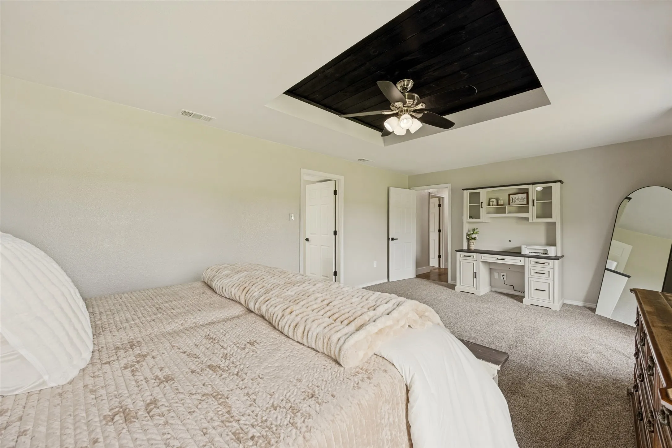 Recessed tray ceiling with dark wood-finish paneling and a ceiling fan with integrated lighting