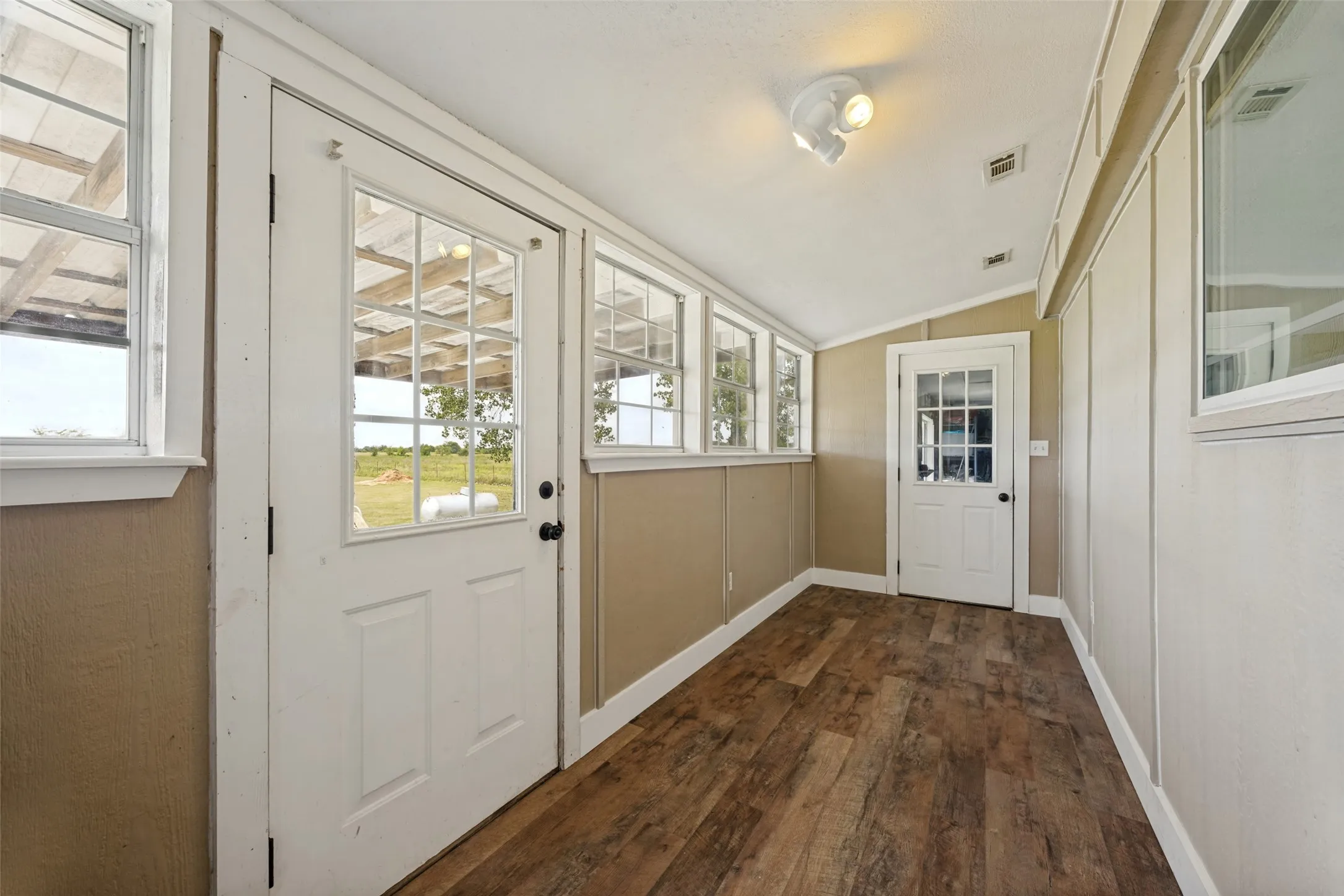 Mud room with wood-finish flooring, multiple windows, and two glass-paneled doors