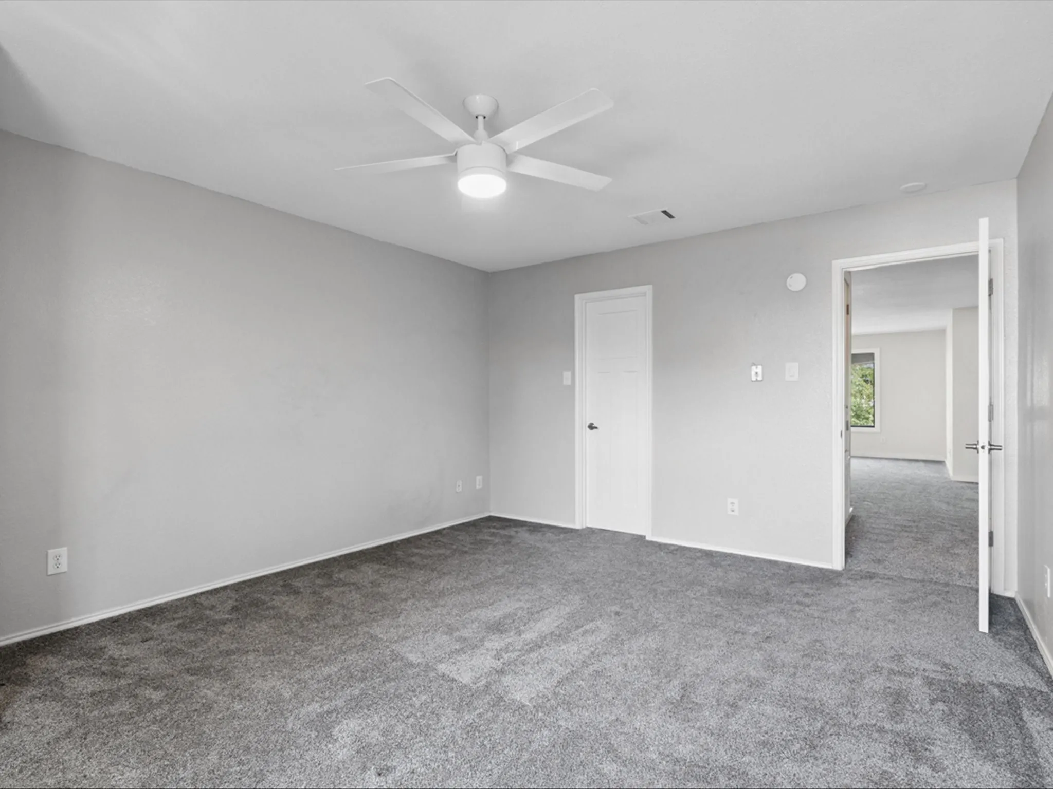 Unfurnished bedroom featuring carpet flooring and ceiling fan