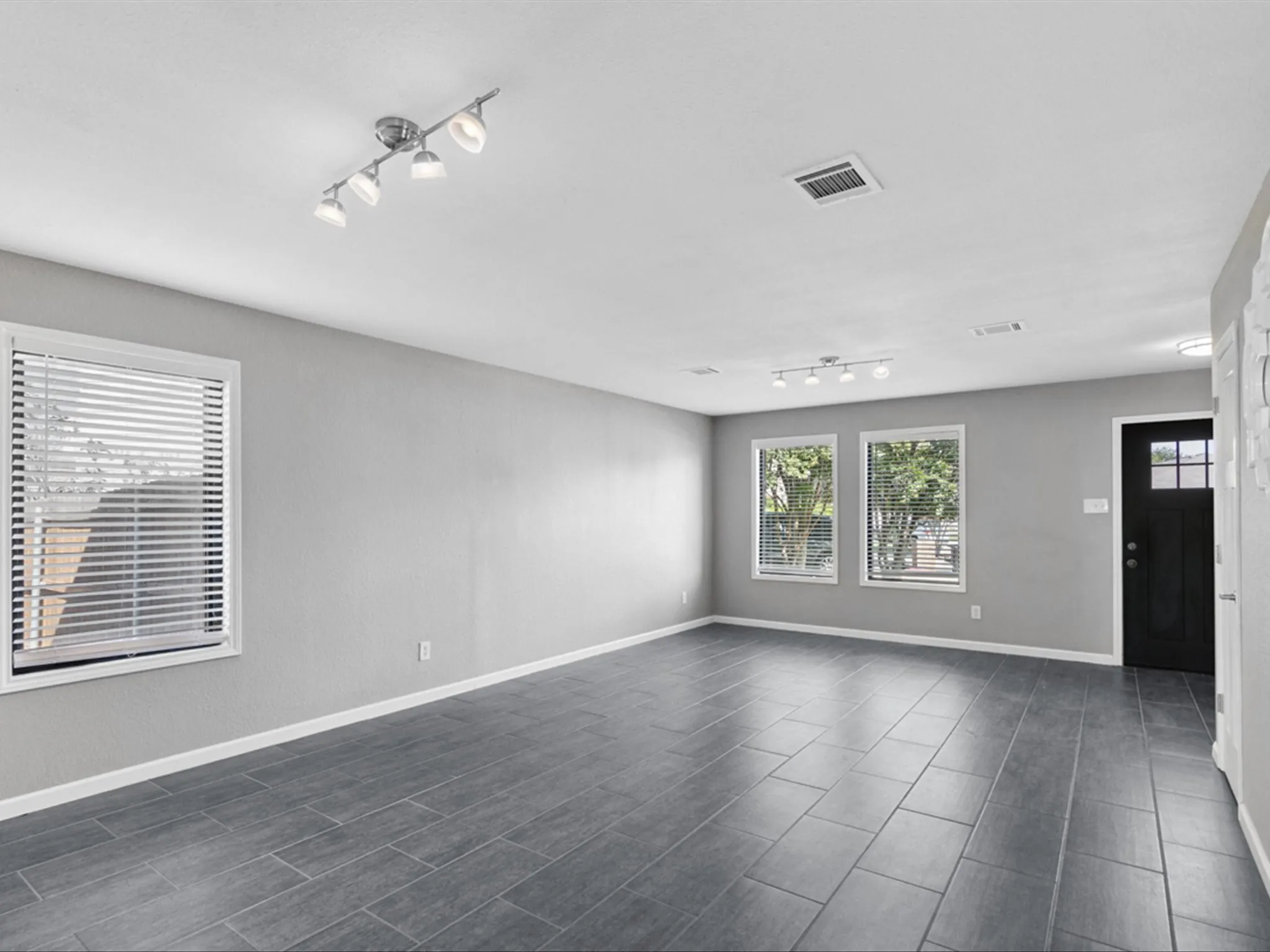 Spare room featuring track lighting and wood tiled floors