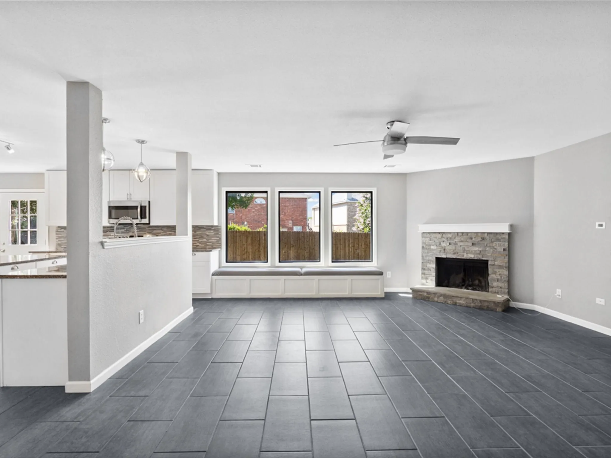 Unfurnished living room featuring a ceiling fan, a fireplace, and wood finish floors