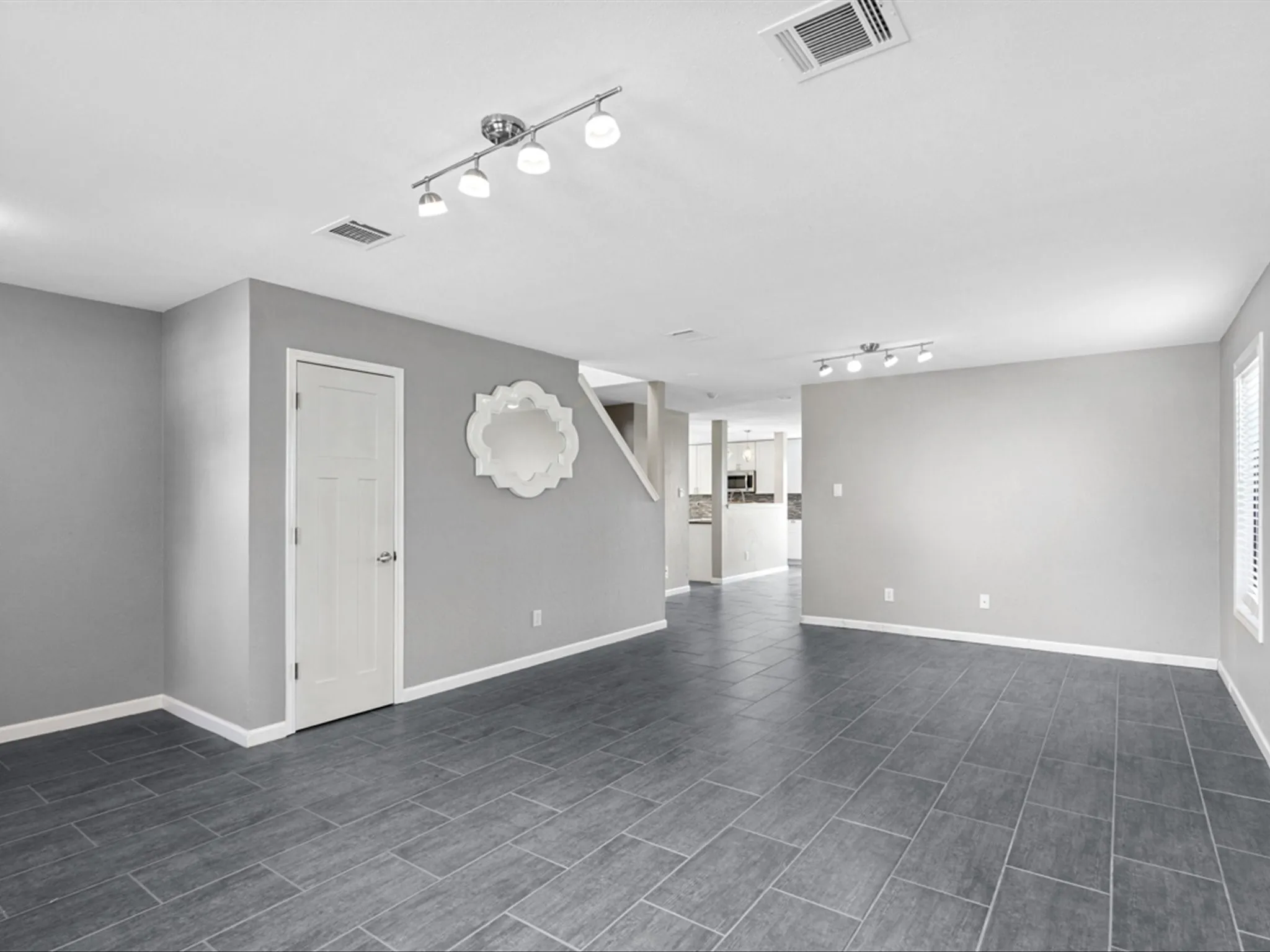 Unfurnished living room featuring rail lighting