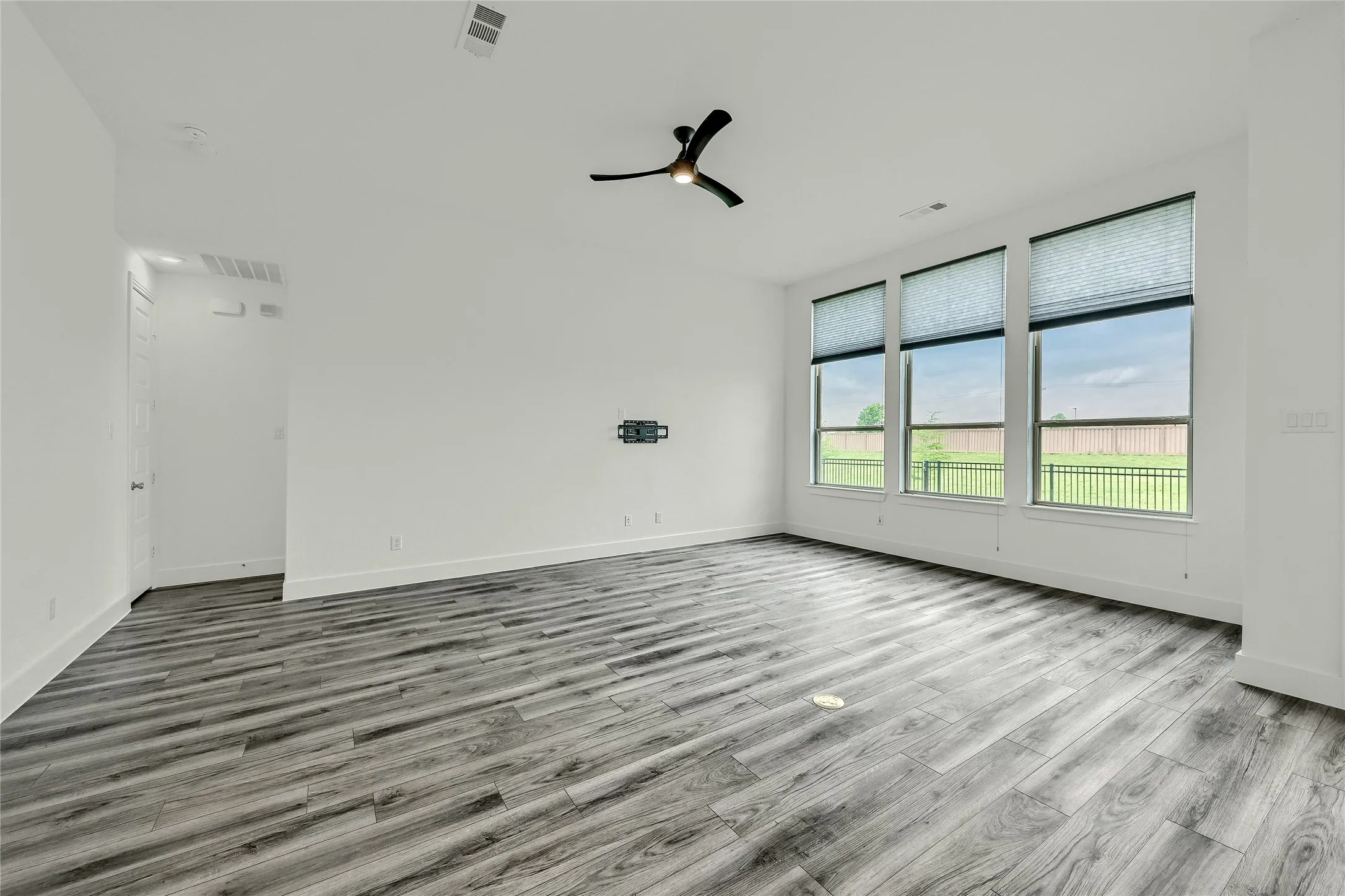 Spare room with visible vents, baseboards, ceiling fan, and wood finished floors